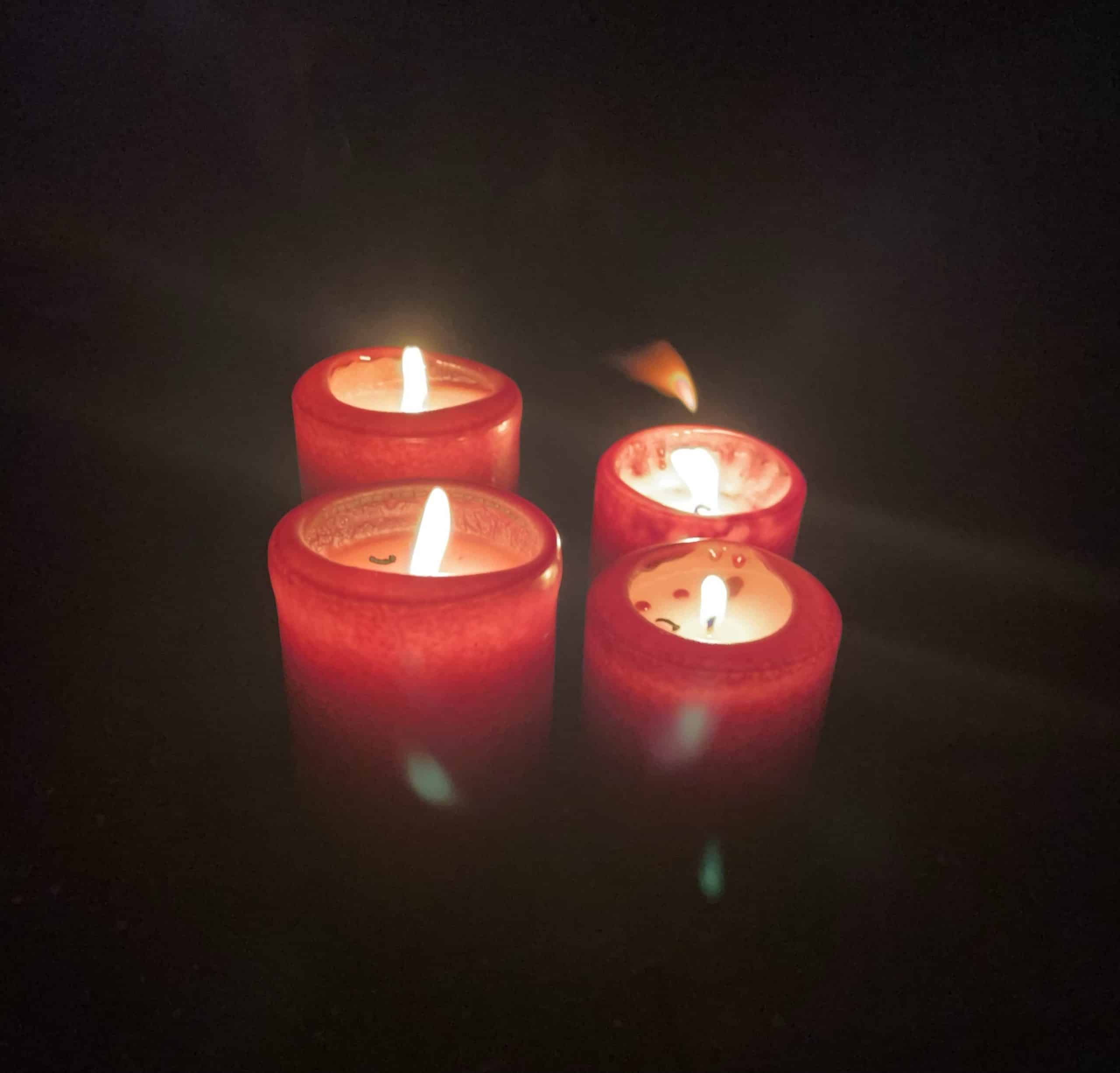 4 rote Kerzen in der Dunkelheit