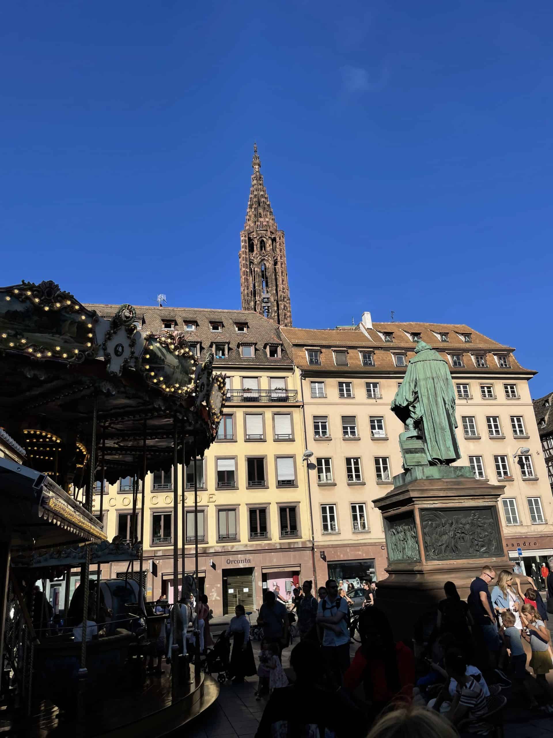Platz mit Statue, im Hintergrund Spitze des Straßburger Münster