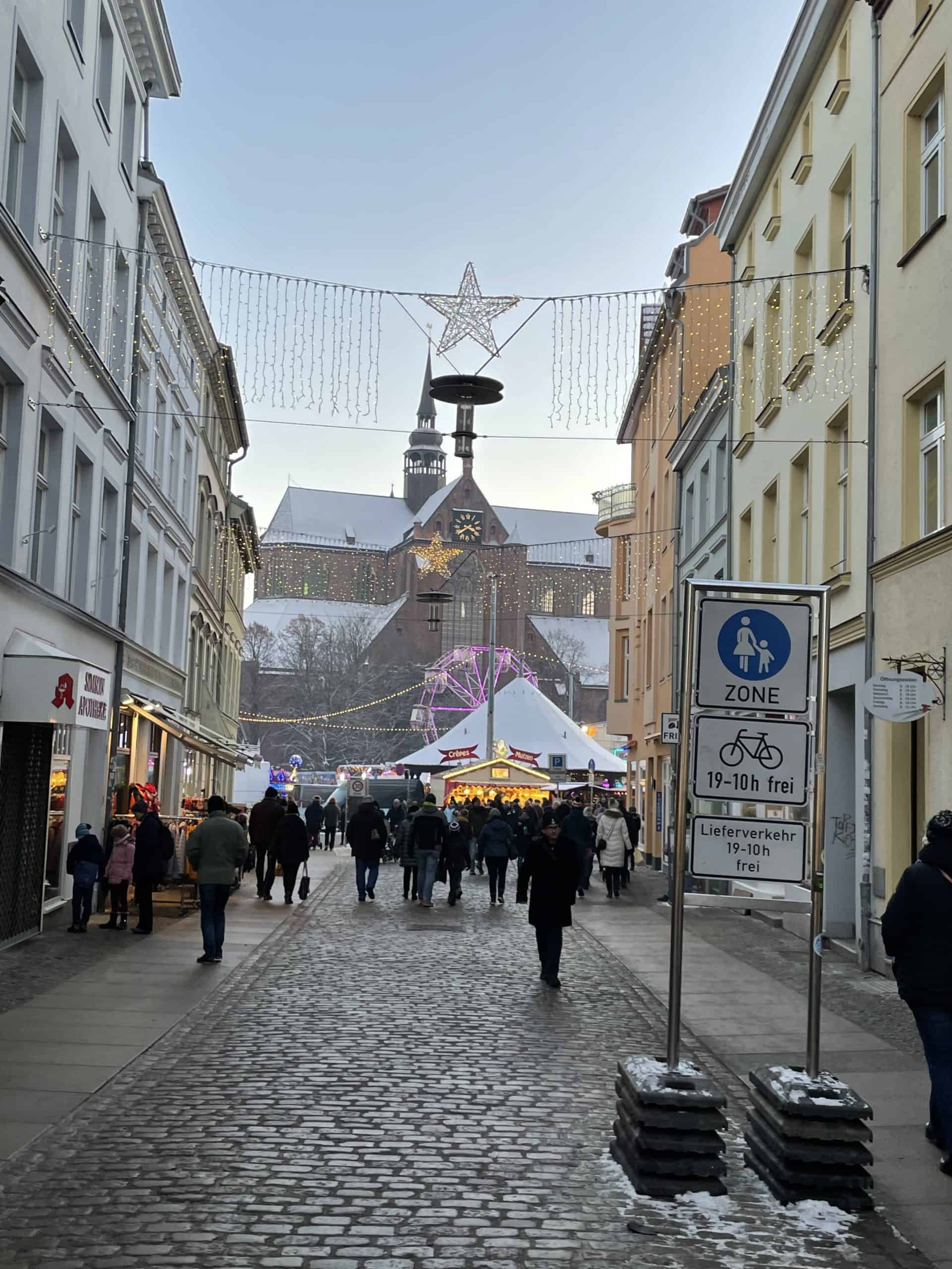Blick in die Fußgängerzone mit Weihnachtsmarkt im Hintergrund