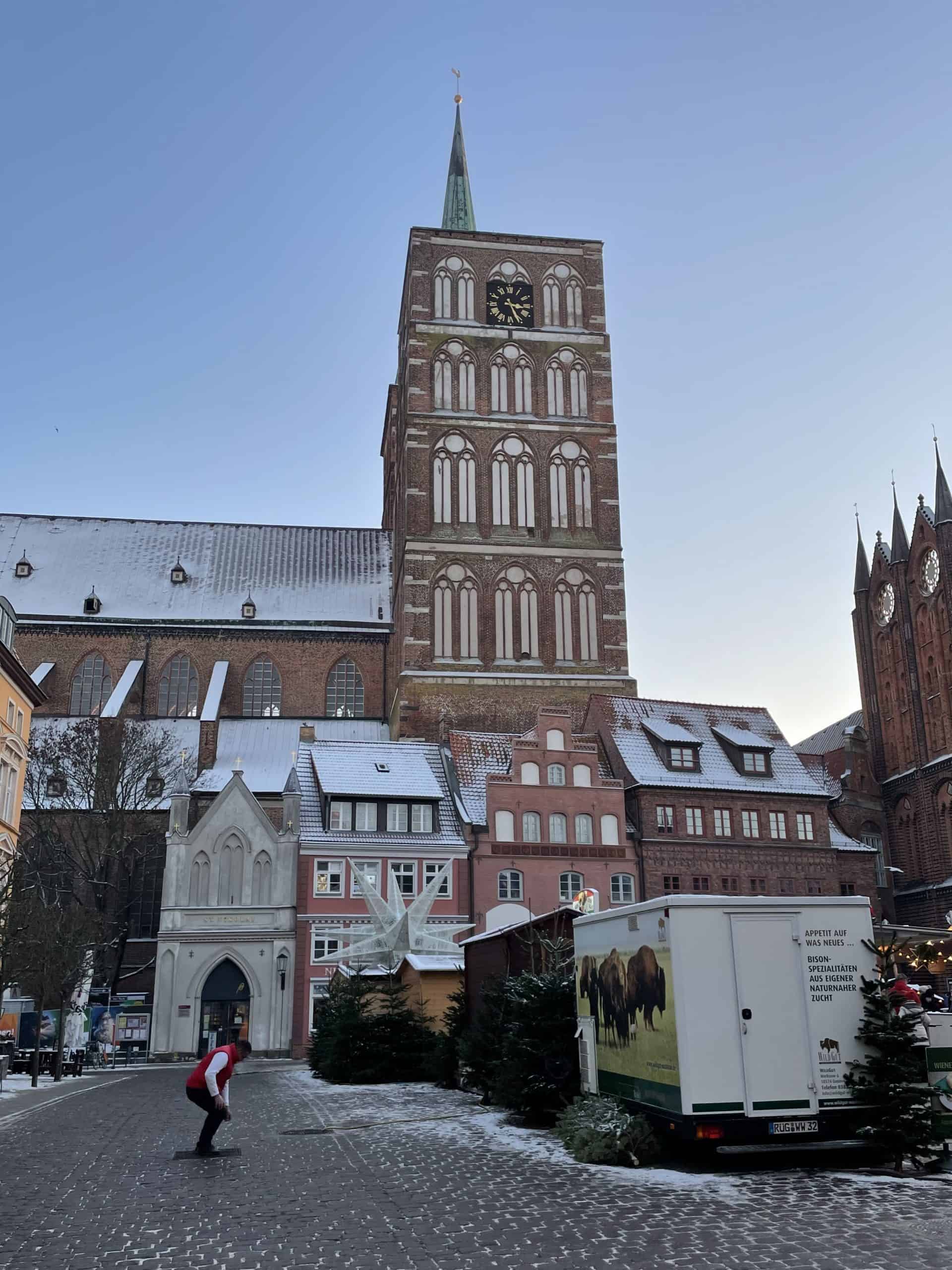 Kirche mit Turm und Weihnachtsmarkt im Vordergrund