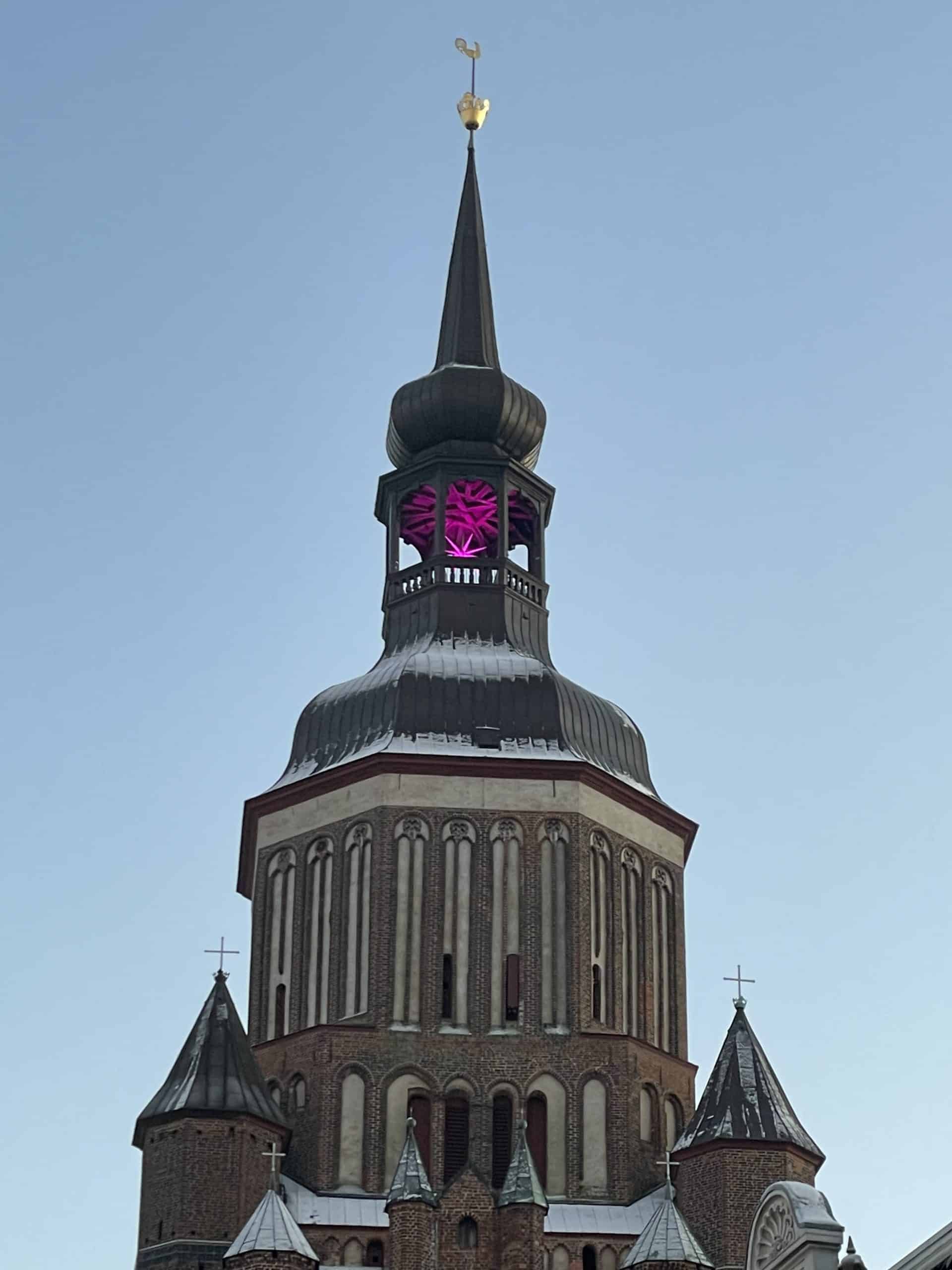 Kirchenturm mit Weihnachtsstern in Magenta in der Kuppel