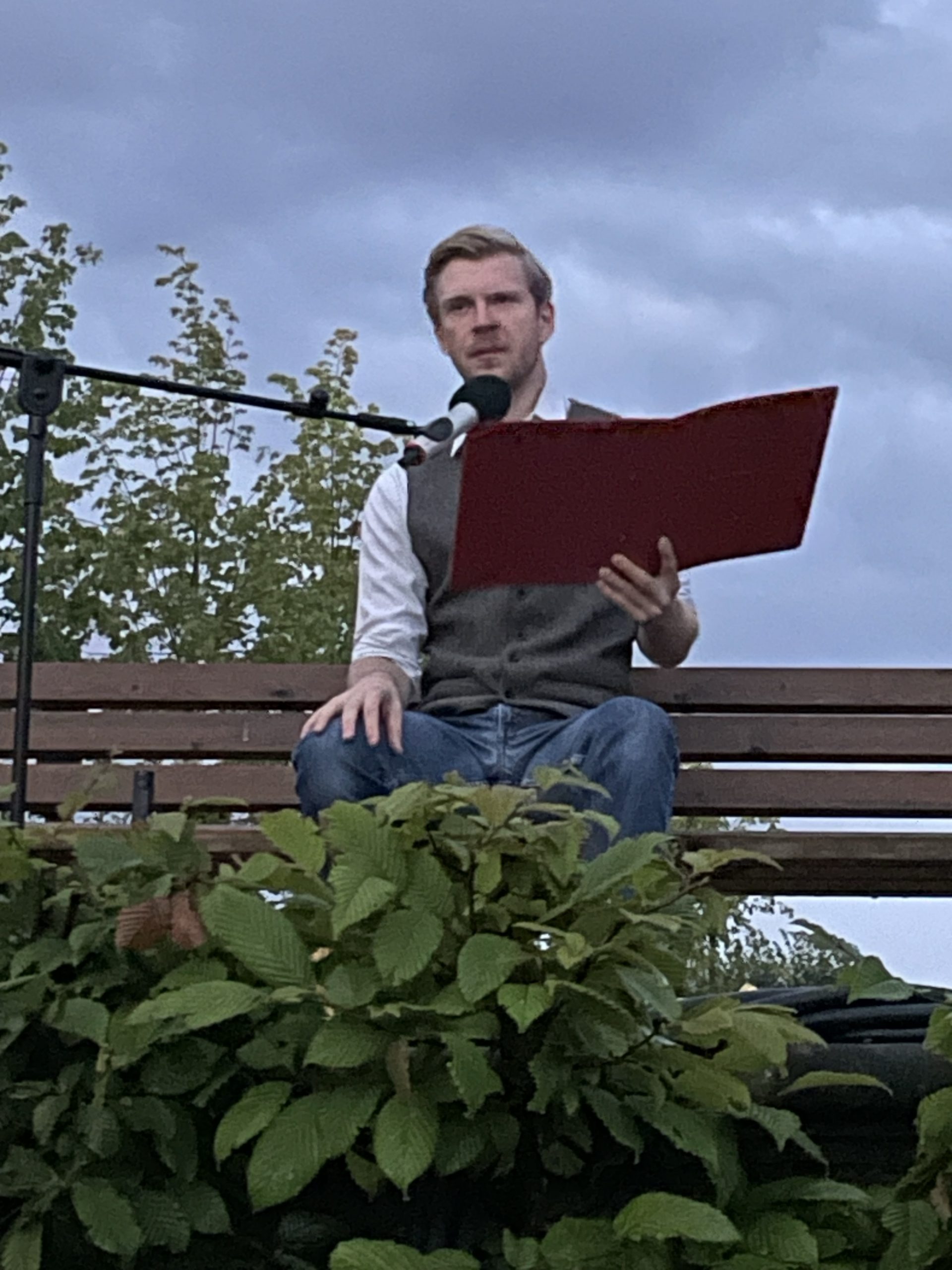 Der Gedichte Lesende auf einer Bank im halbdunkelnen