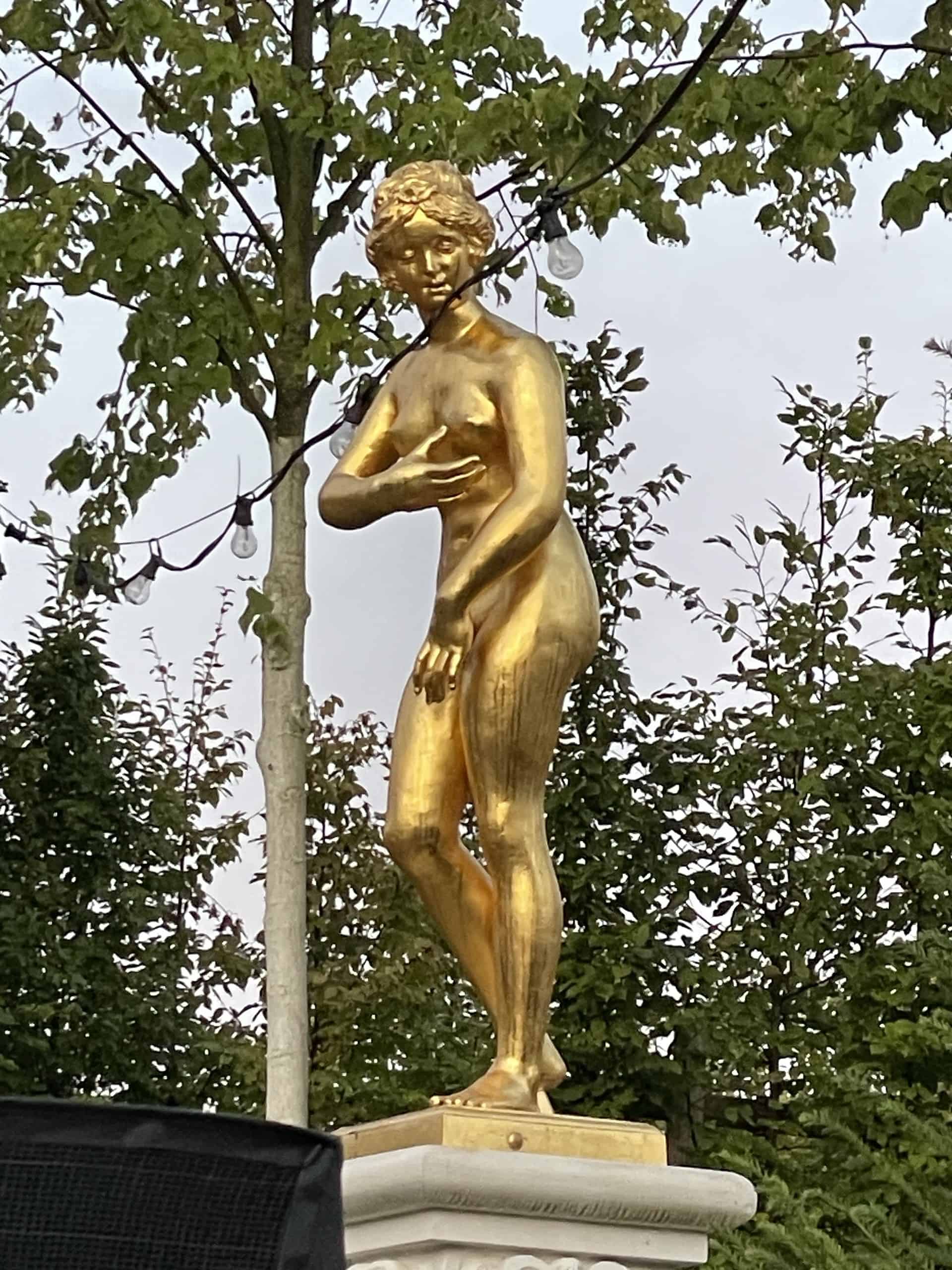 Fast schon taghell, golden, nackte Frauenfigur rechter Hand auf der Bühne des Gartentheaters in Herrenhasusen.
