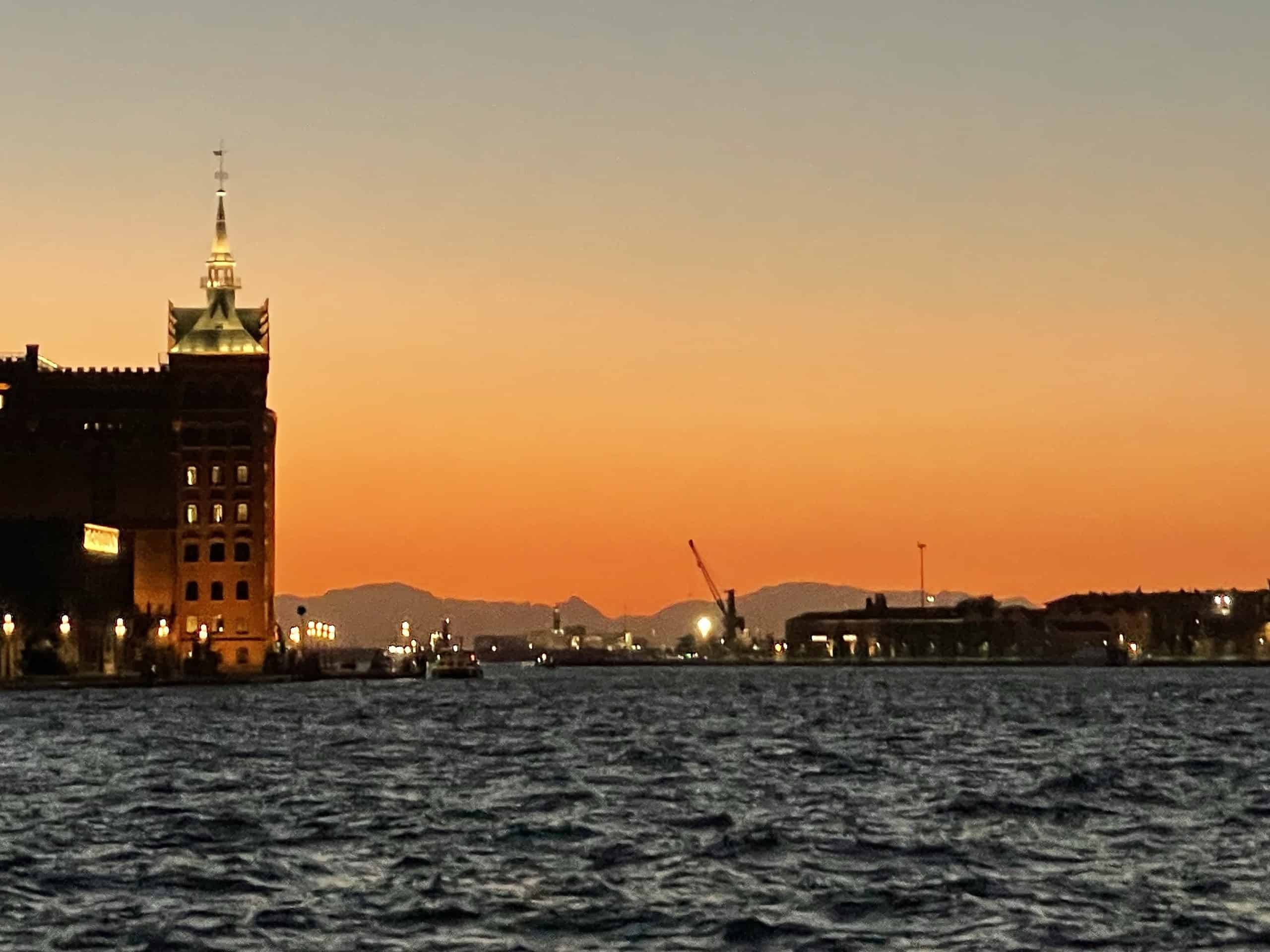 Venedig vom Vaporetti am Abend mit rot-orangem Sonnenuntergang.