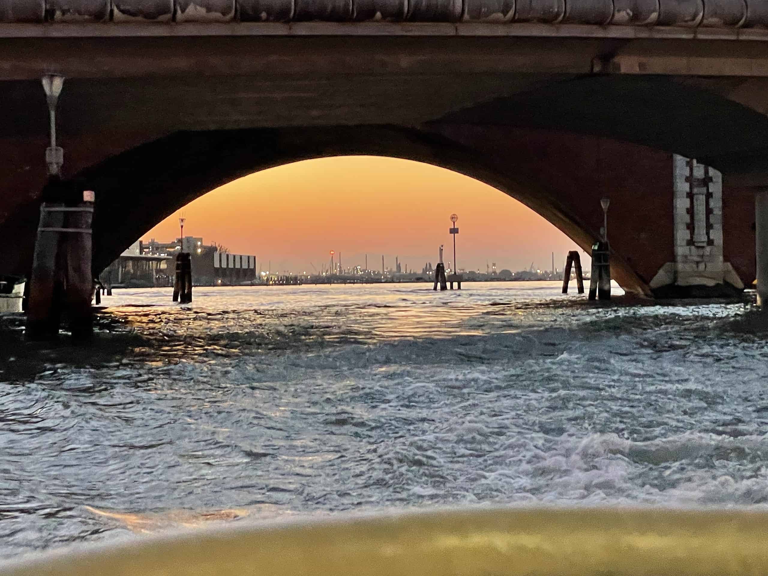 Abendliche Kanalbrücke, durch die das Abendrot in Venedig scheint, vom Vaporetti aus fotografiert.