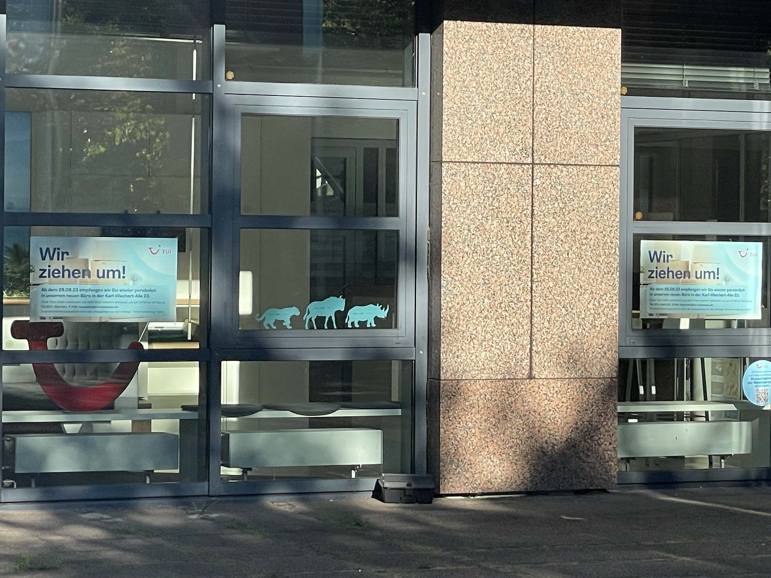 Eingangsbereich der TUI AG mit Wir-sind-umgezogen-Schildern an den Türen.