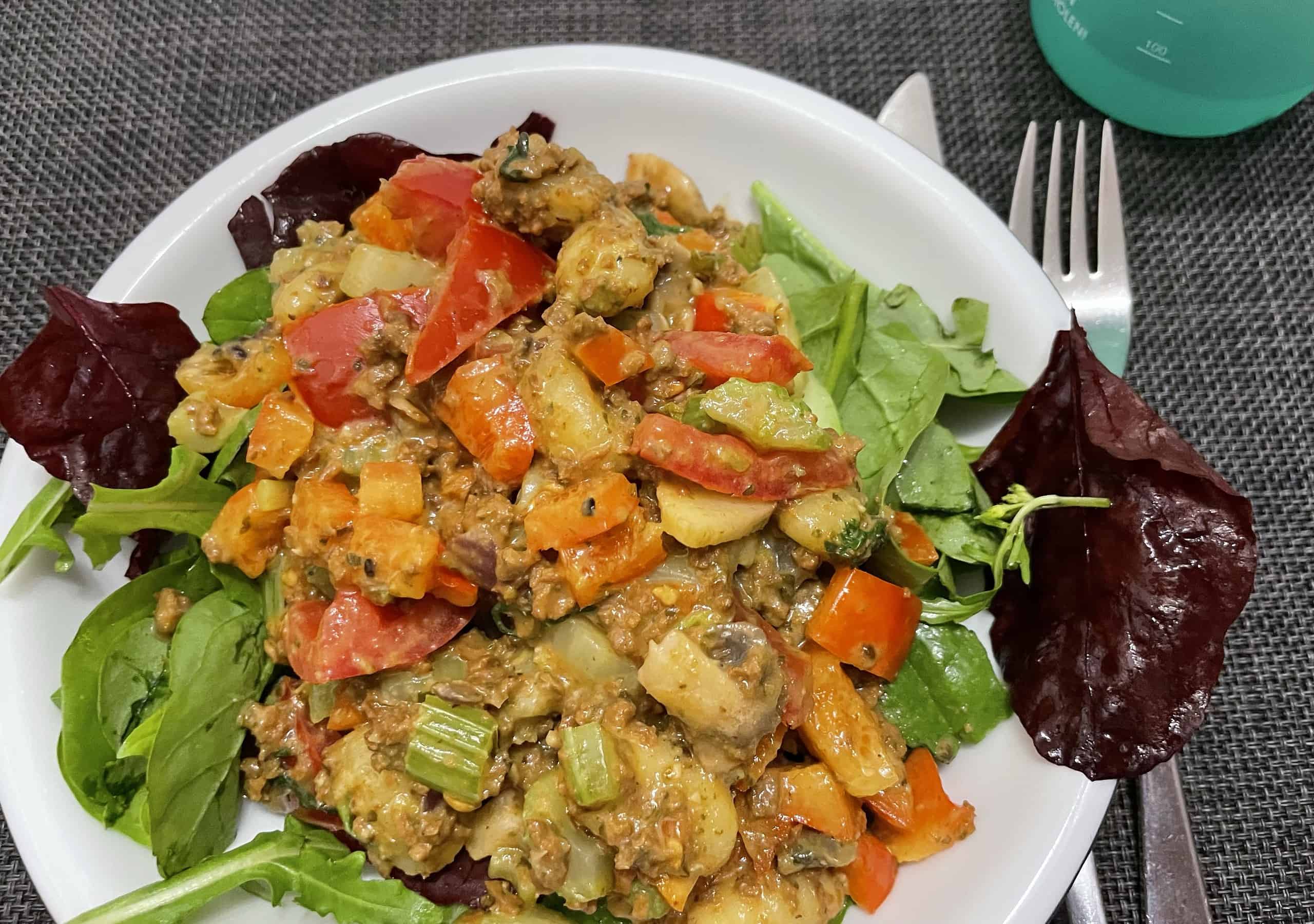 Veganes Gericht mit Champignons, Tofu und Gemüse an Salat.