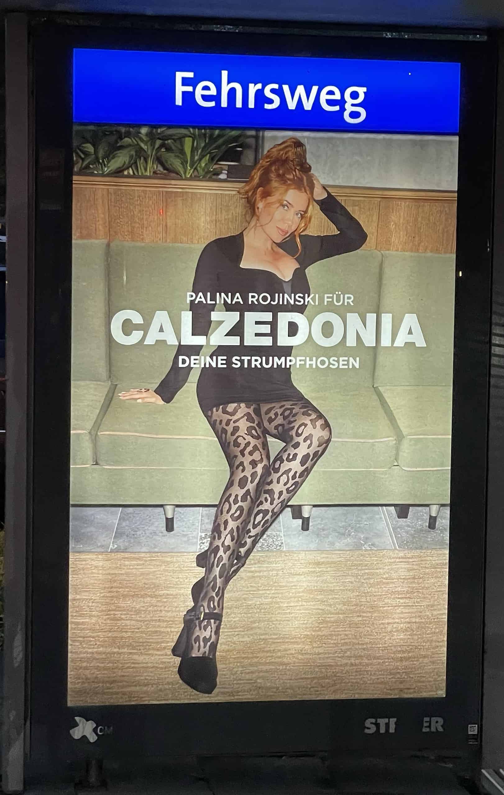 Sexy Palina Rojinski in schwarzem, kurzem Kleid und böickdichter grauer Strumpfhiose mit schwarzem Raubkatzenmuster sowie schwarzen High Heels macht Calzedonia-Reklame.
