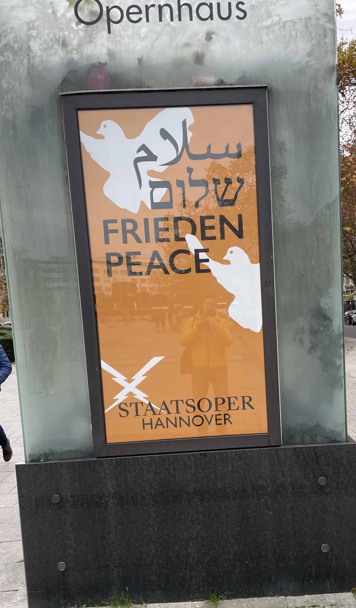 Plakat der Oper mit Frieden, auch in Hebräisch.