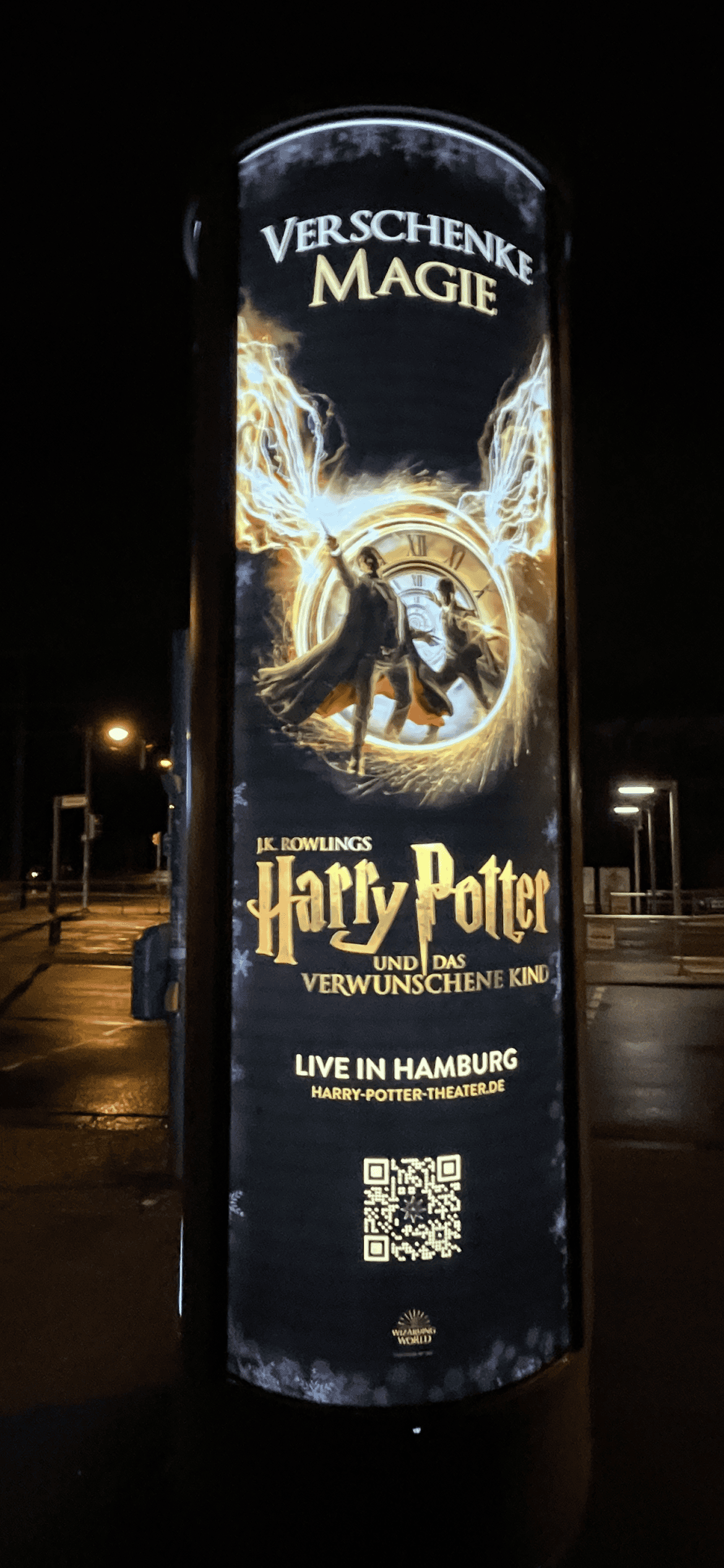 Litfaßsäule im Dunkeln mit leuchtender Harry Potter Theaterreklame in Hamburg.