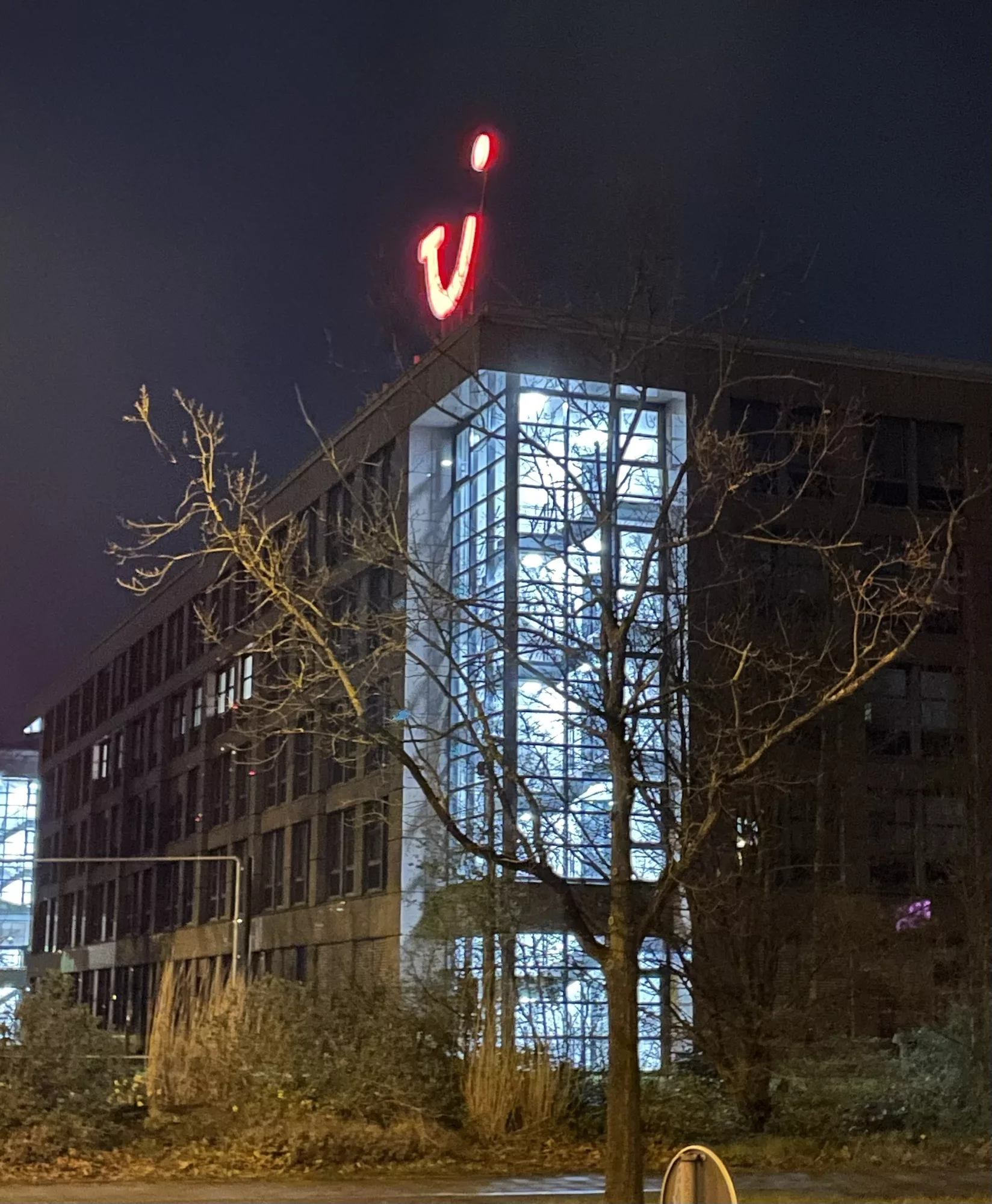 Nächtliche Sicht auf das Ex-TUi-Gebäude in der Karl-Wiechert-Allee 4, wo im Treppenhaus Licht brennt und das rote TUI-Logo auf dem Dach weithin sichtbar strahlt.