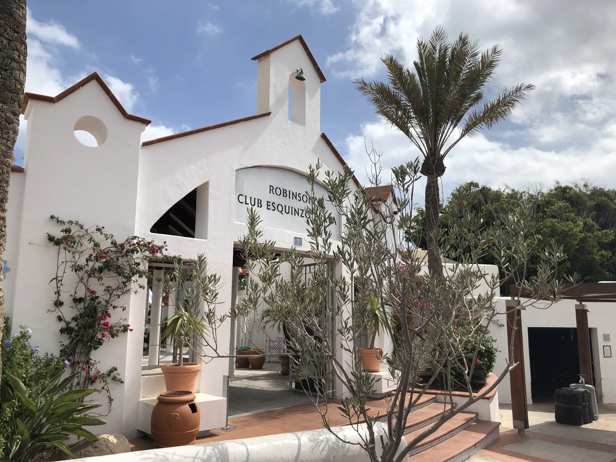 Weiße Fassade mit Palmen: Der Eingang vom Robinson Club Esquinzo Playa.