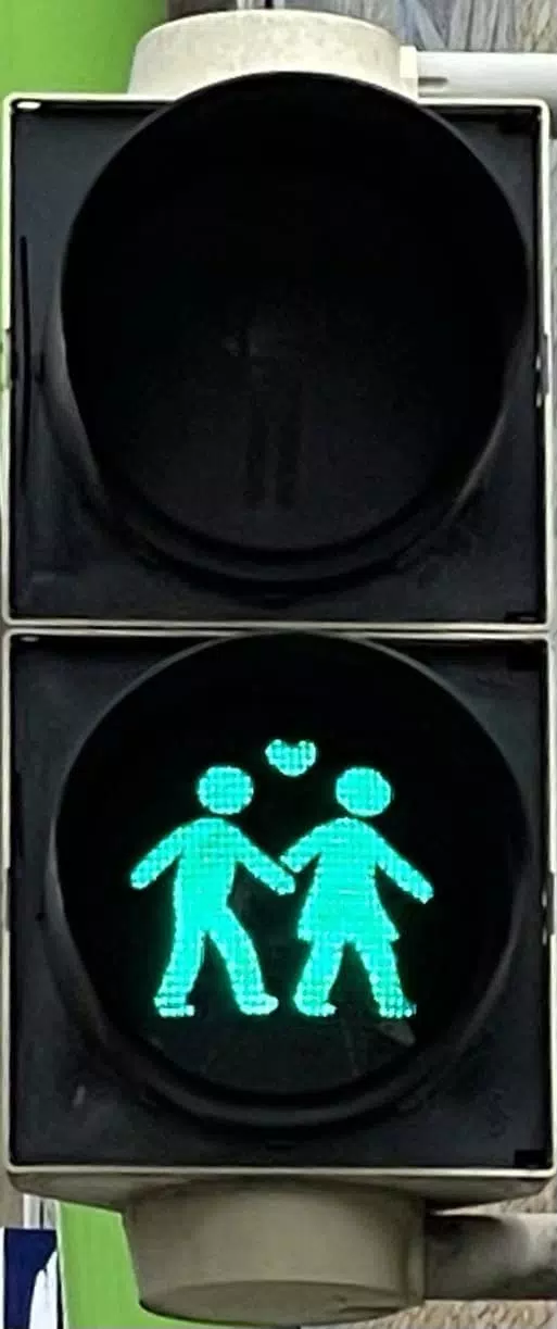 Fußgängerampel mit Grün. Als Symbol ein sich am Arm haltenes Paar (männlich und weiblich) mit Herz zwischen beiden.