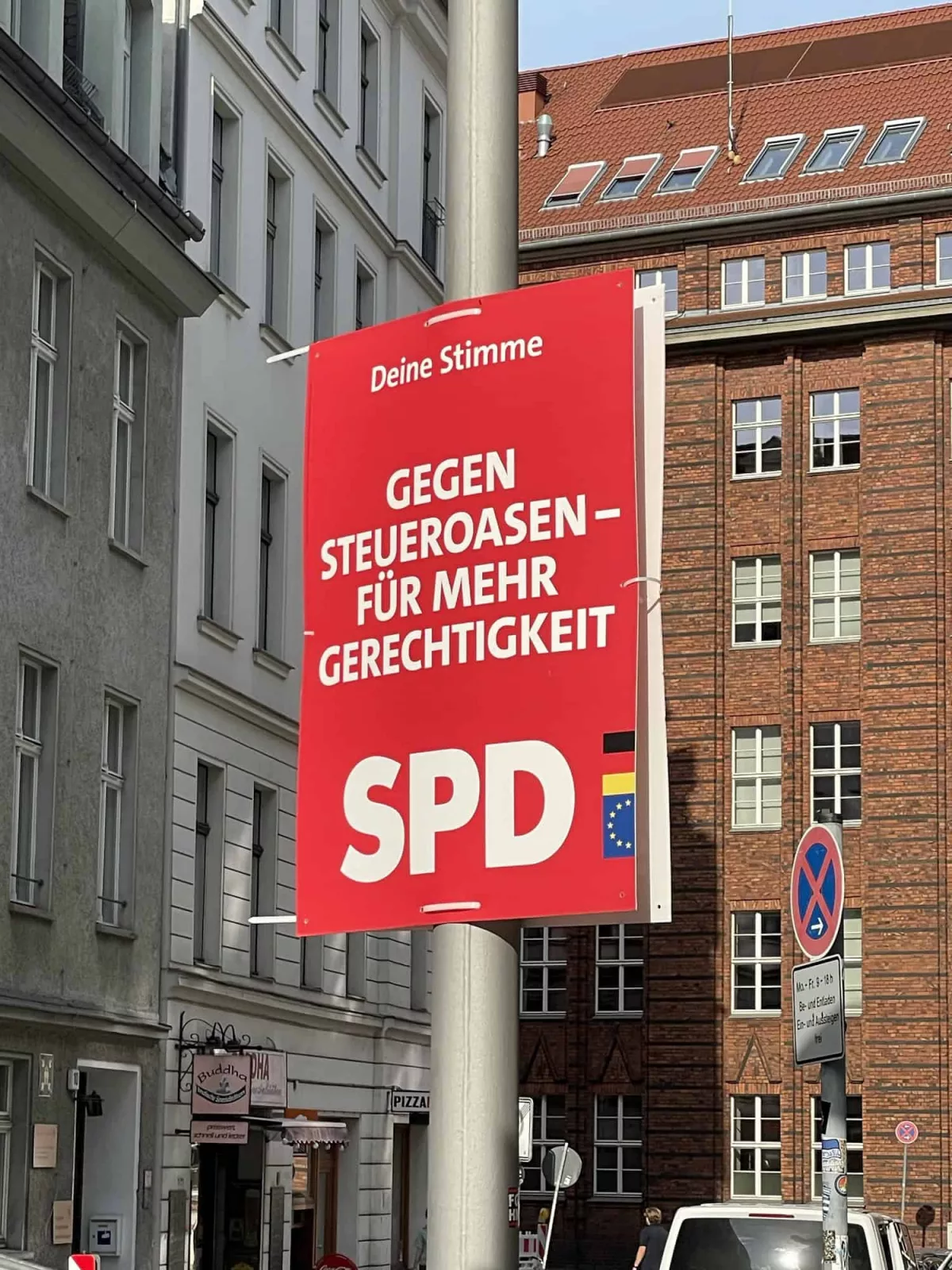 Straße in Berlin mit Laterne und dort SPD-Wahlplakat mit Sloagen: Deine Stimme GEGEN STEUEROASEN - FÜR MEHR GERECHTIGKEIT.