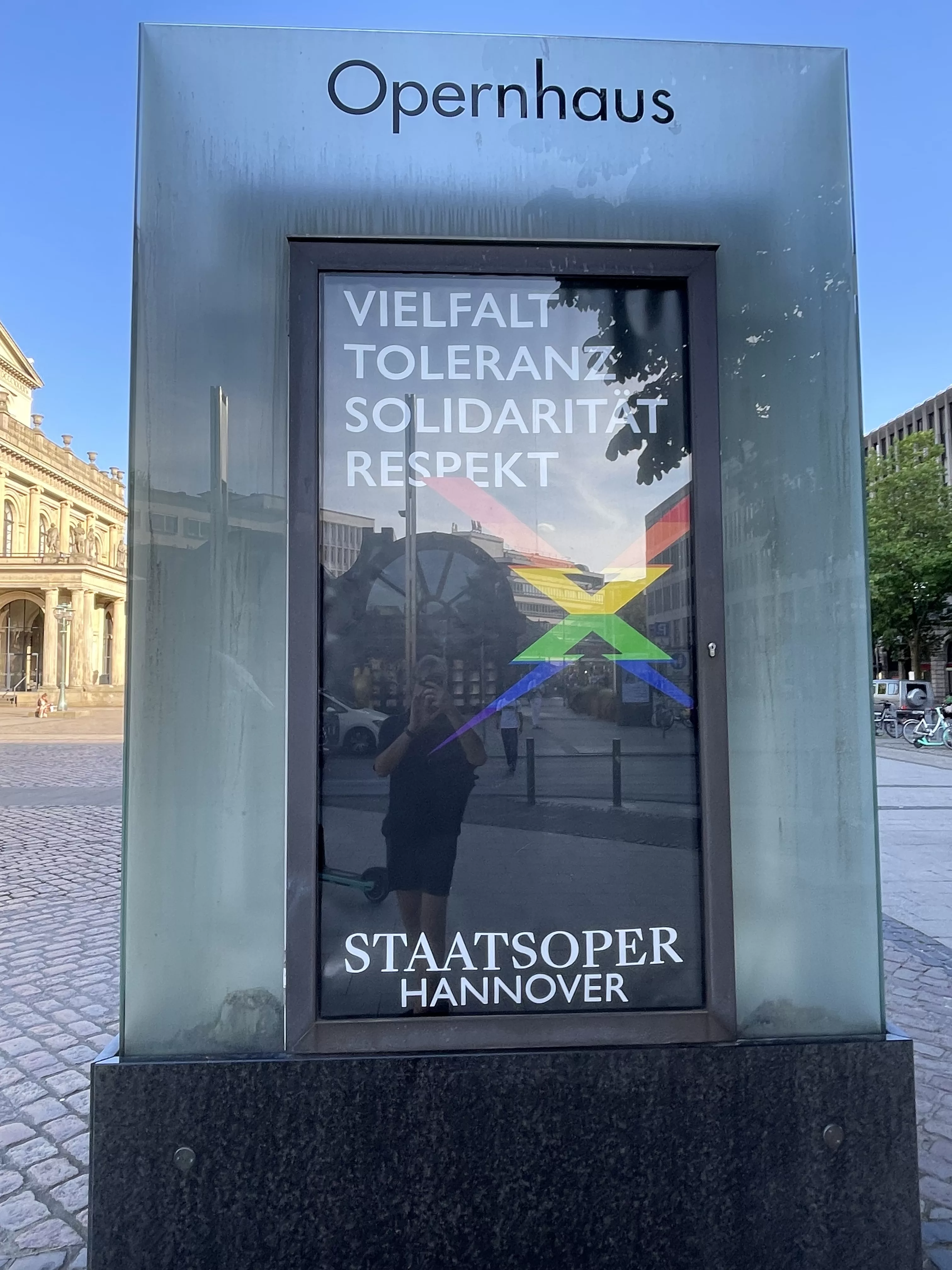 Außeninfo des Opernhauses Hannover zu Vielfalt, Toleranz, Solidarität und Respekt mit Regenbogen-X der niedersächsischen Staatsoper. 