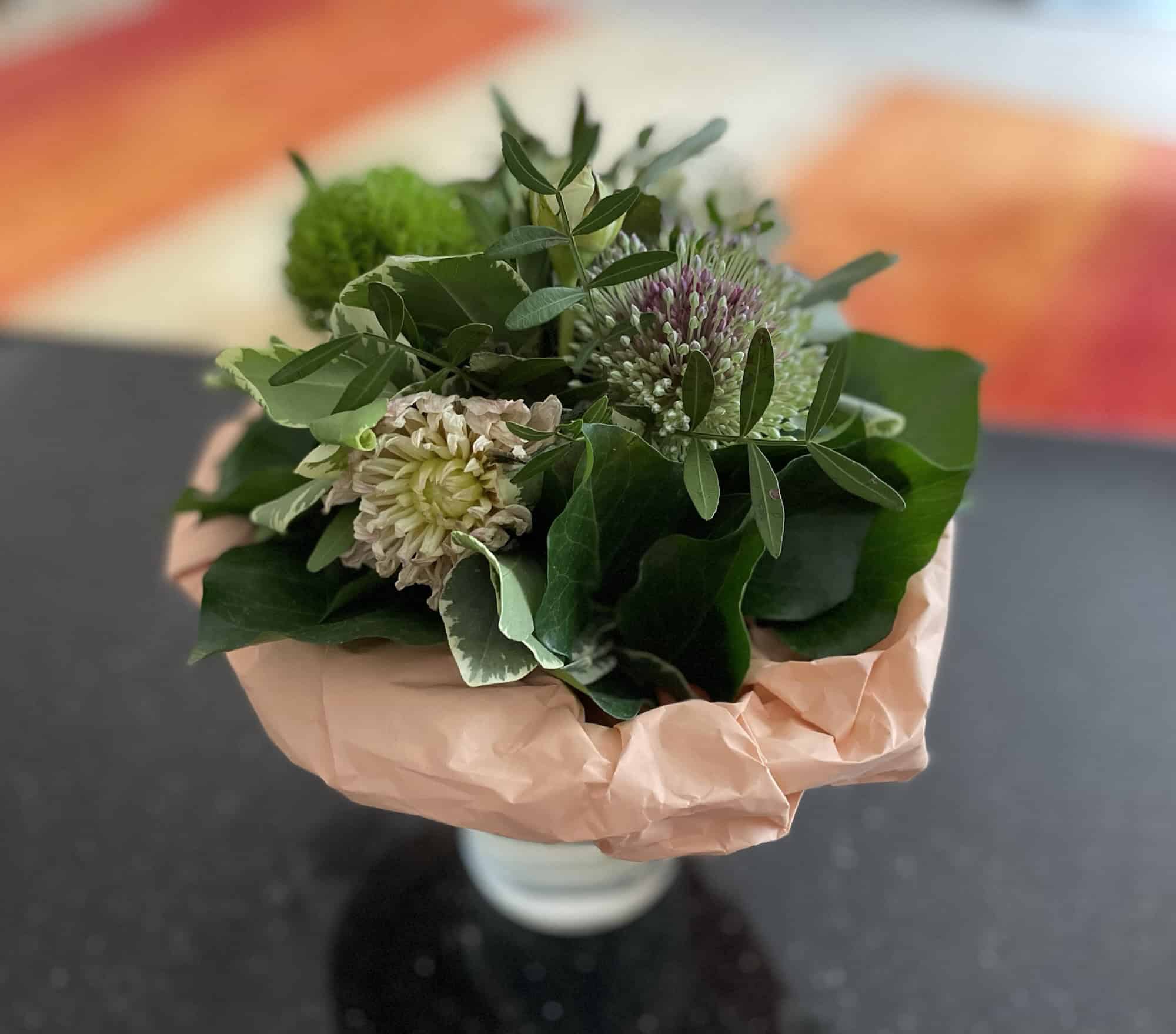 Ein grün, weißer Blumenstrauß in der Vase.