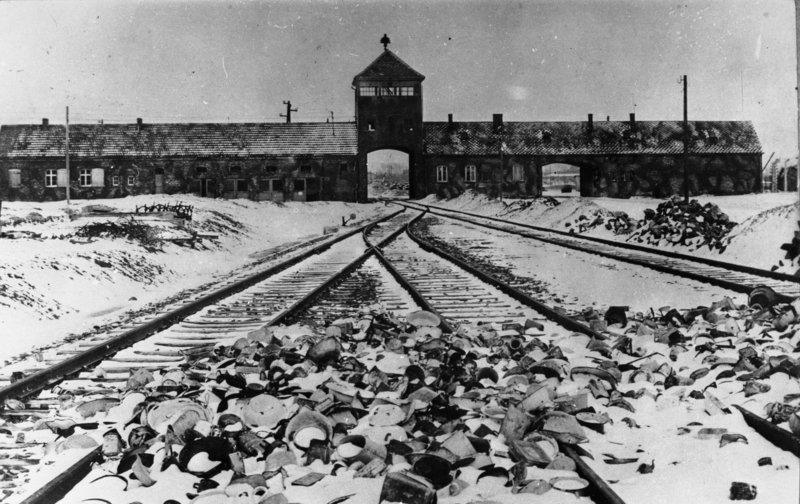 Schwarzweißbild im Winter 1945 der Eisenbahneinfahrt in das Konzentrationslager Auschwitz.