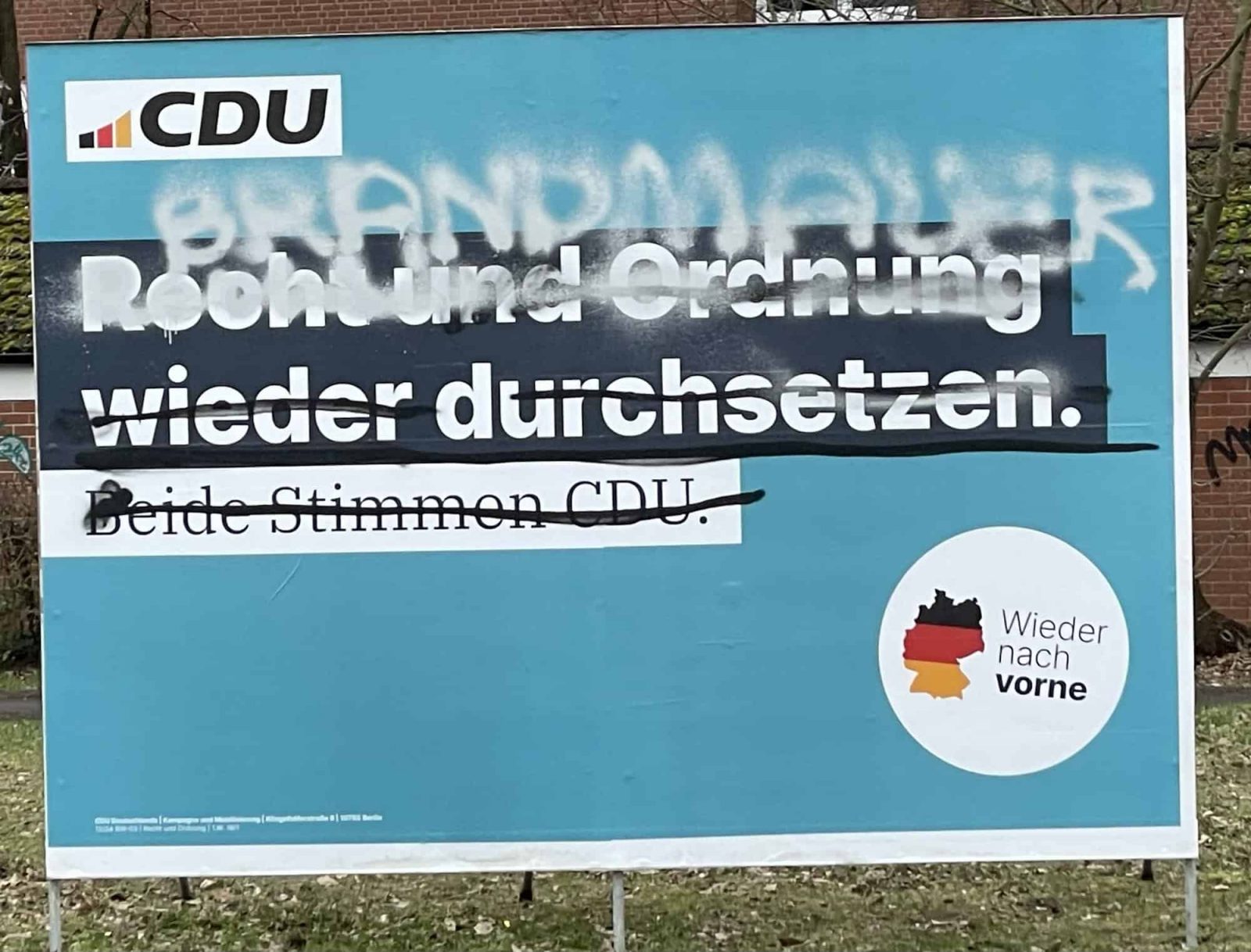 CDU-Wahlplakat: Sliagen übersprüht und Brandmauerschriftzug.
