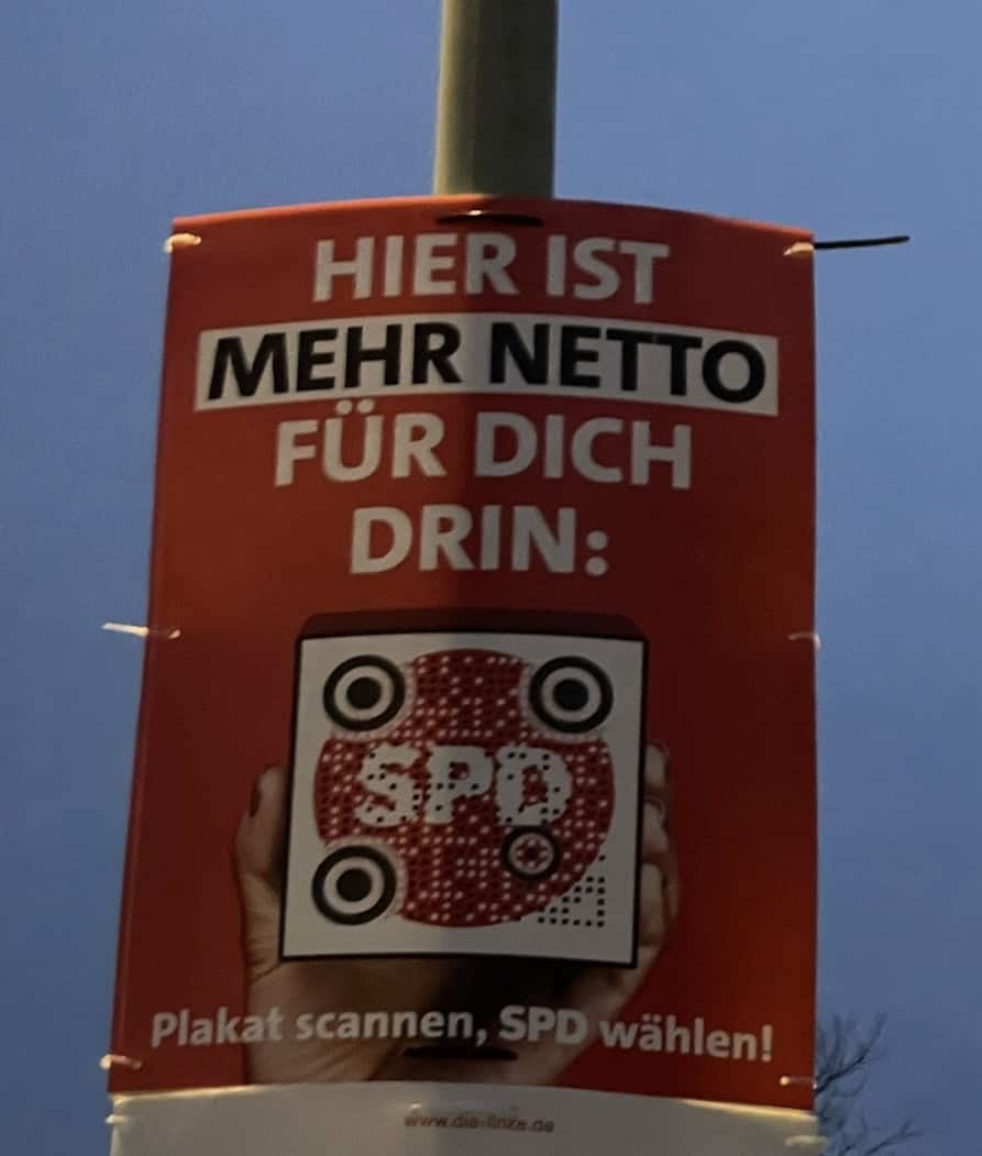 SPD Wahlkampfplakat: 'Hier ist mehr netto für Dich drin' und ein einer der Hand gehaltener Punkt-Barcode.