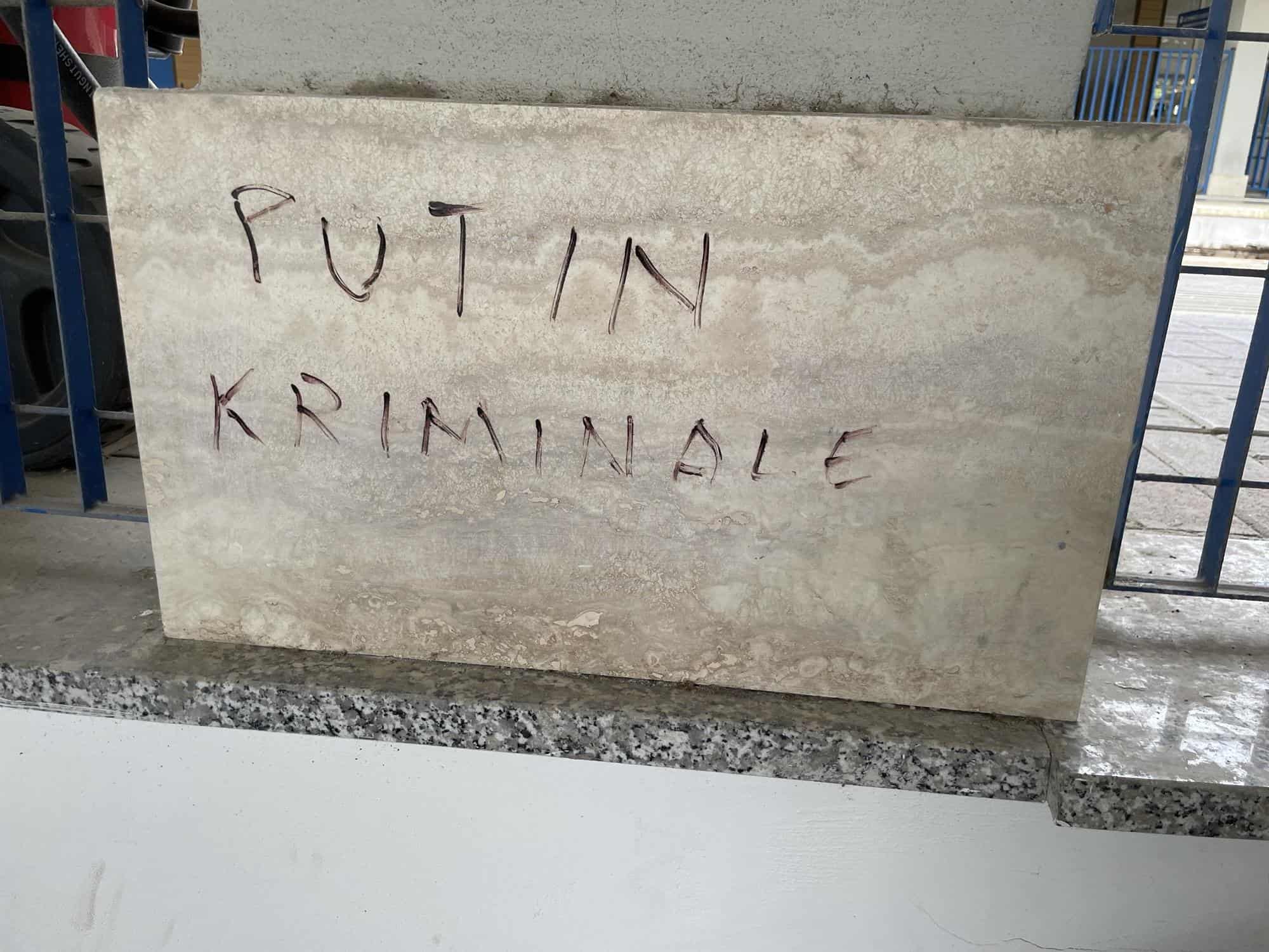Naturstein an einem Treppenabgang mit Schriftzug: PUTIN KRIMINALE