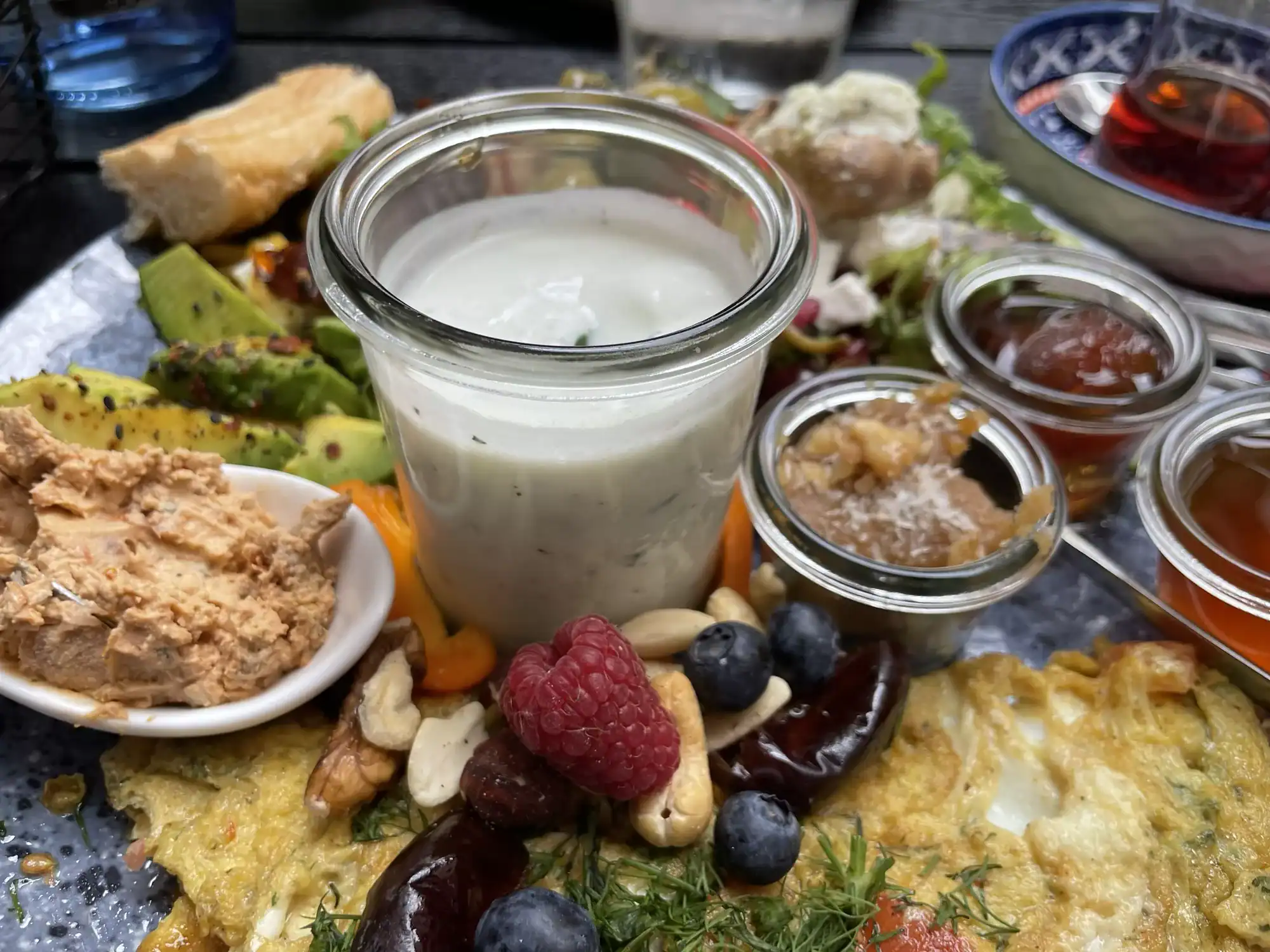 Persisches Frühstück mit weißem Dressingvubdcsüßw und sakzige Frühstücksbestandteile darum