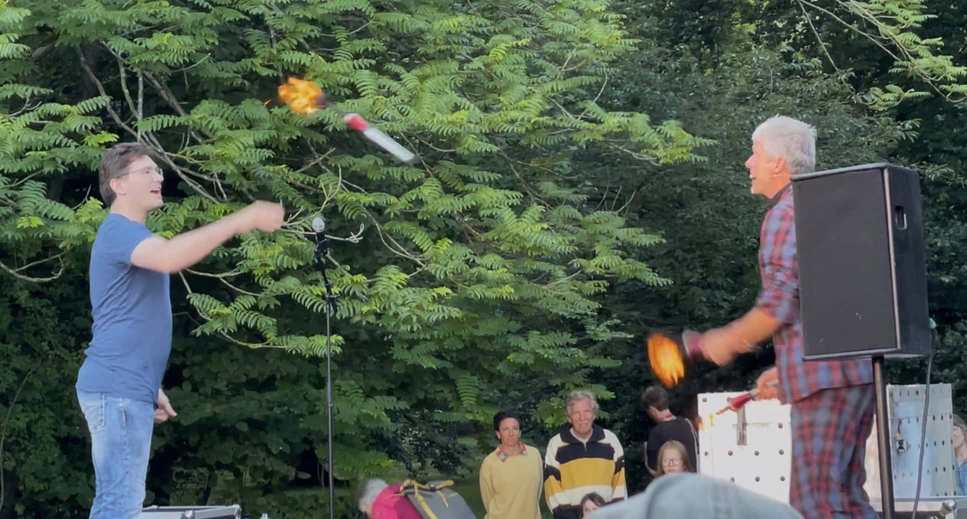 Jens Ohle mit seinem Freiwilligen, der ihm die brennde Jonglierfackel zuwirft.
