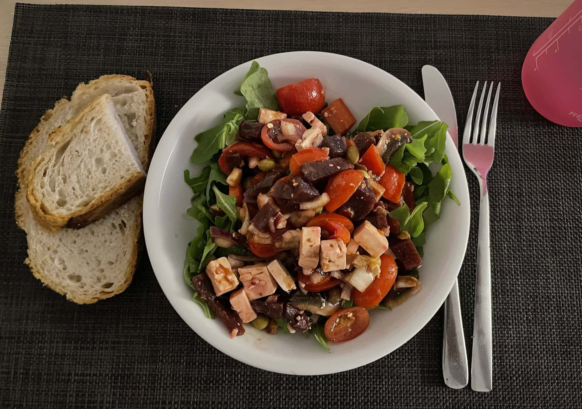 Teller Ruccolasalat mit Rote Beete veganem Hühnerfleisch, Tomaten und Paprika