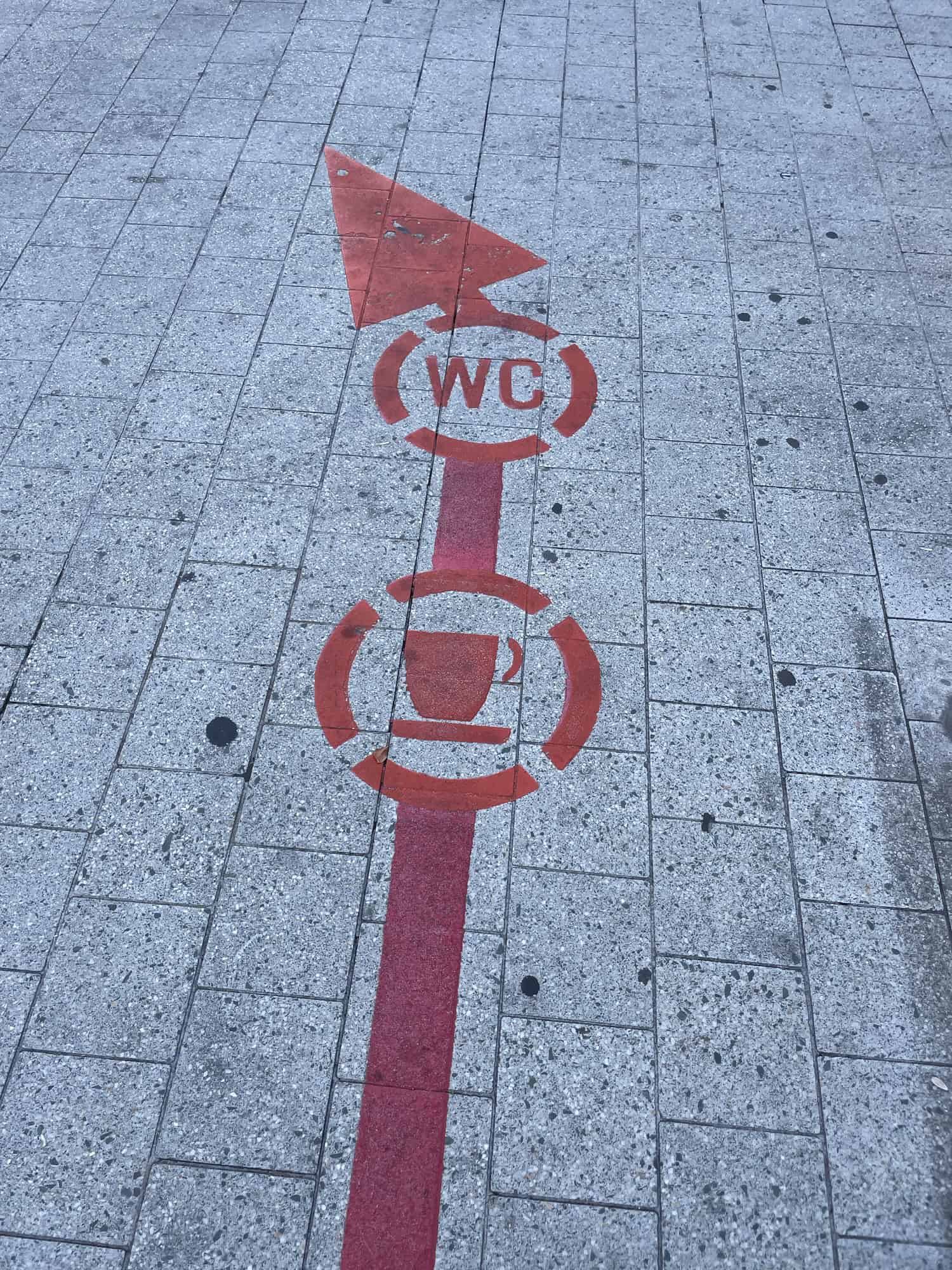 Stück vom Roten Faden mit Kaffetassenwegweiser unf Toilettenwegweiser.