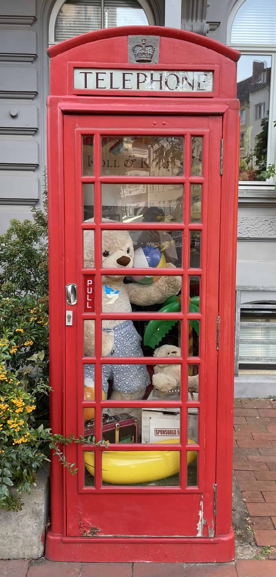 Englische rote Telefonzelle mit Teddybären darin.