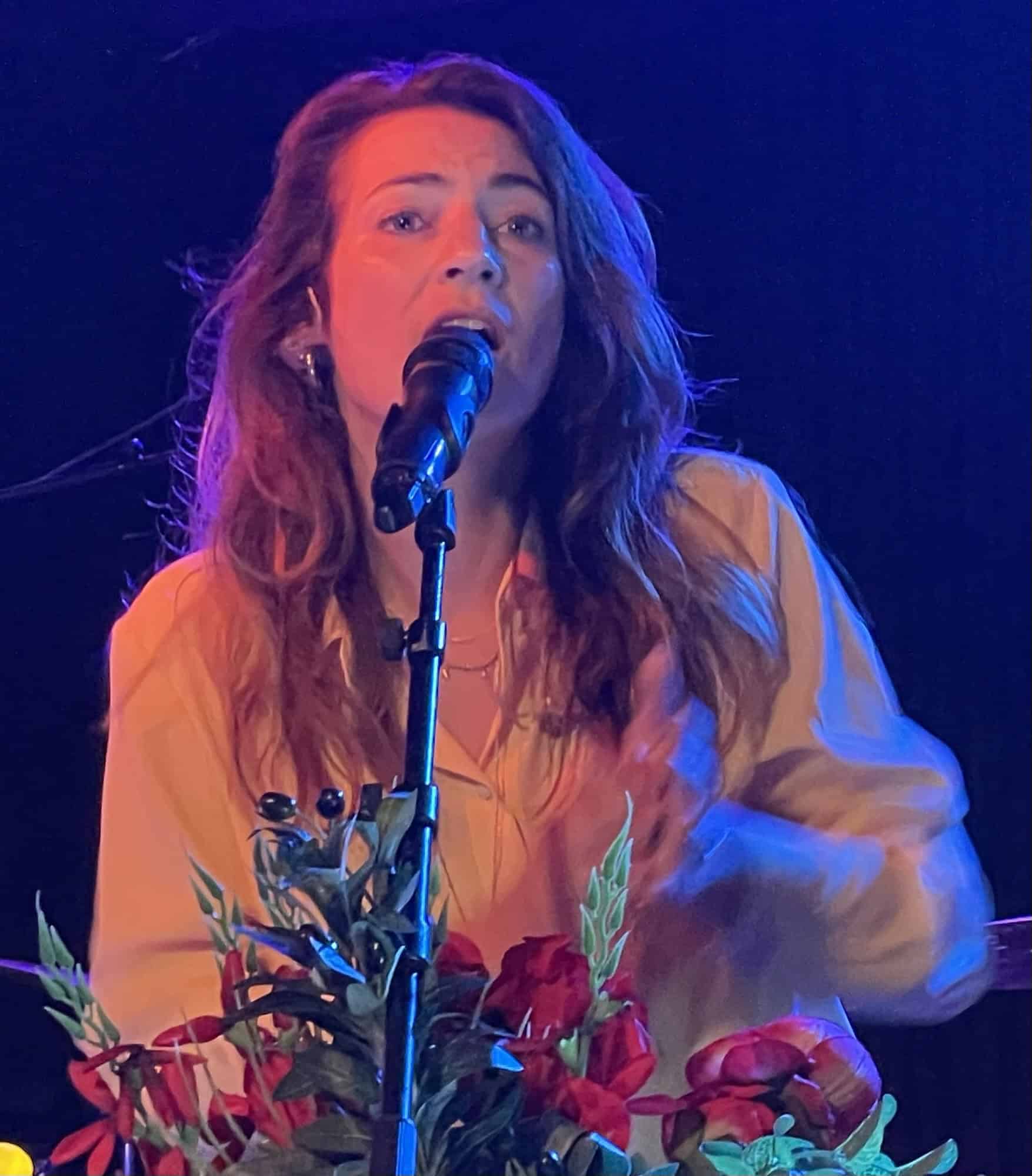 Luca Vasta singt, vor ihr das Mikrrofon mit Blumenschmuck.