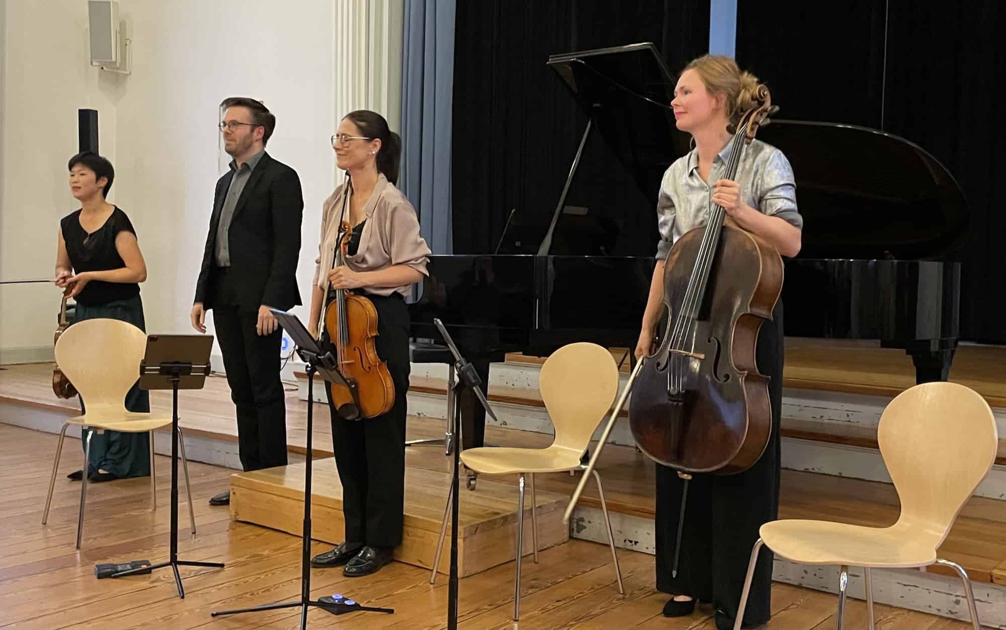 Die Musiker stehen und halten ihre Instrumentr und bekommen ihre Applaus.