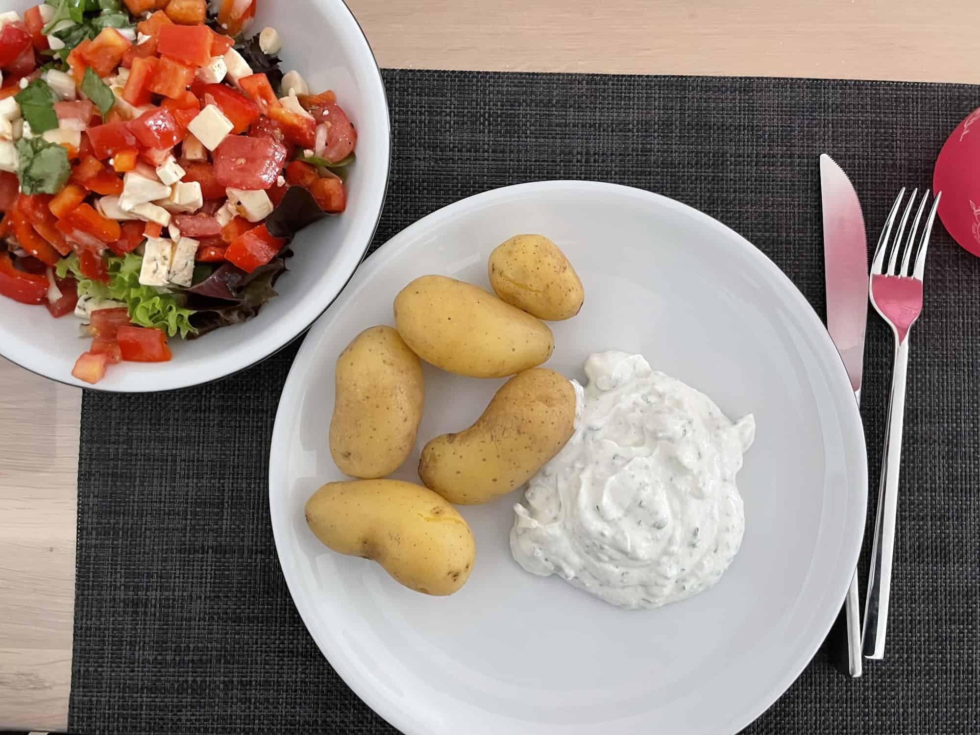 Teller gemischter Salat an Teller mit Kartoffeln mit Schale, Quark und Keinenöl.