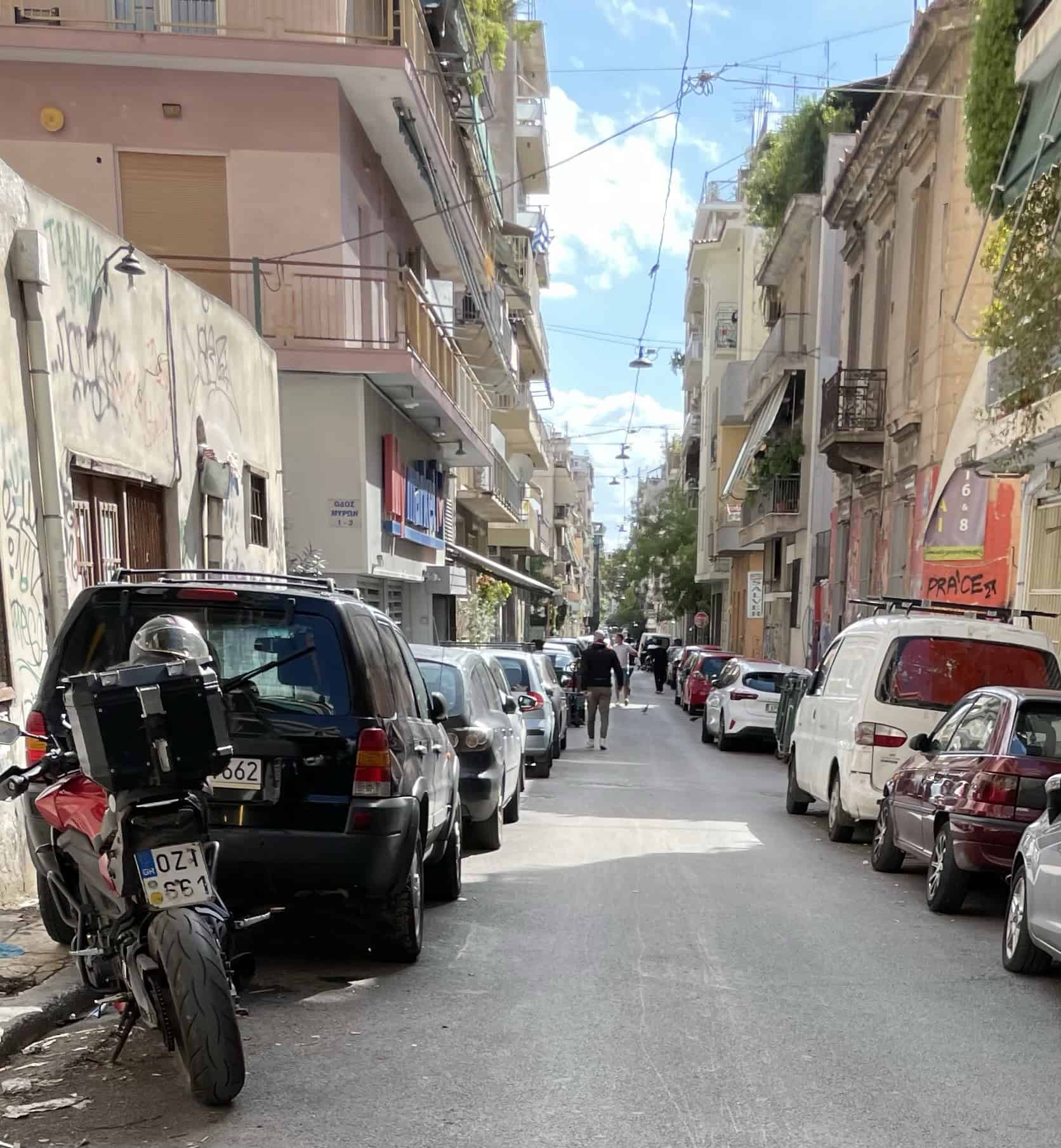 Blick eine schmale Straße zwischen den Häuserzeilen hinunter, links und techts zugeparkt.