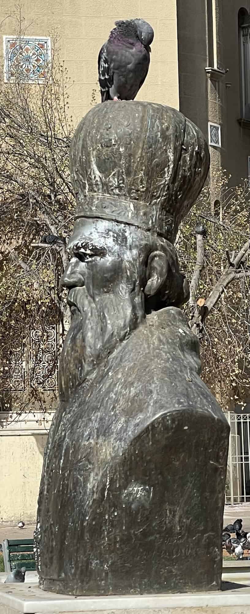 Eine Popenbüste mit Taube auf dem Kopf.