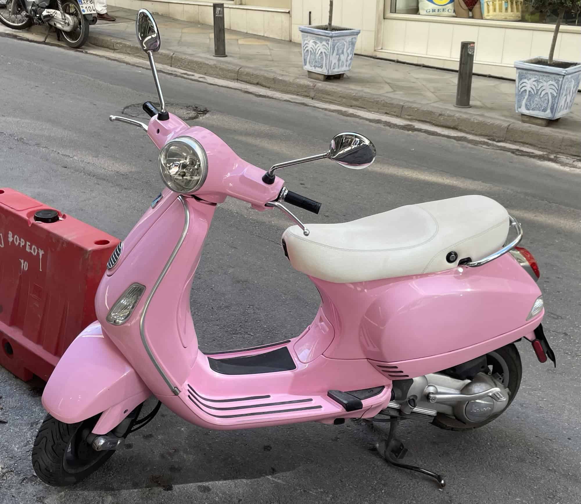 Eine rosa Vespa mit weißem Sattel,