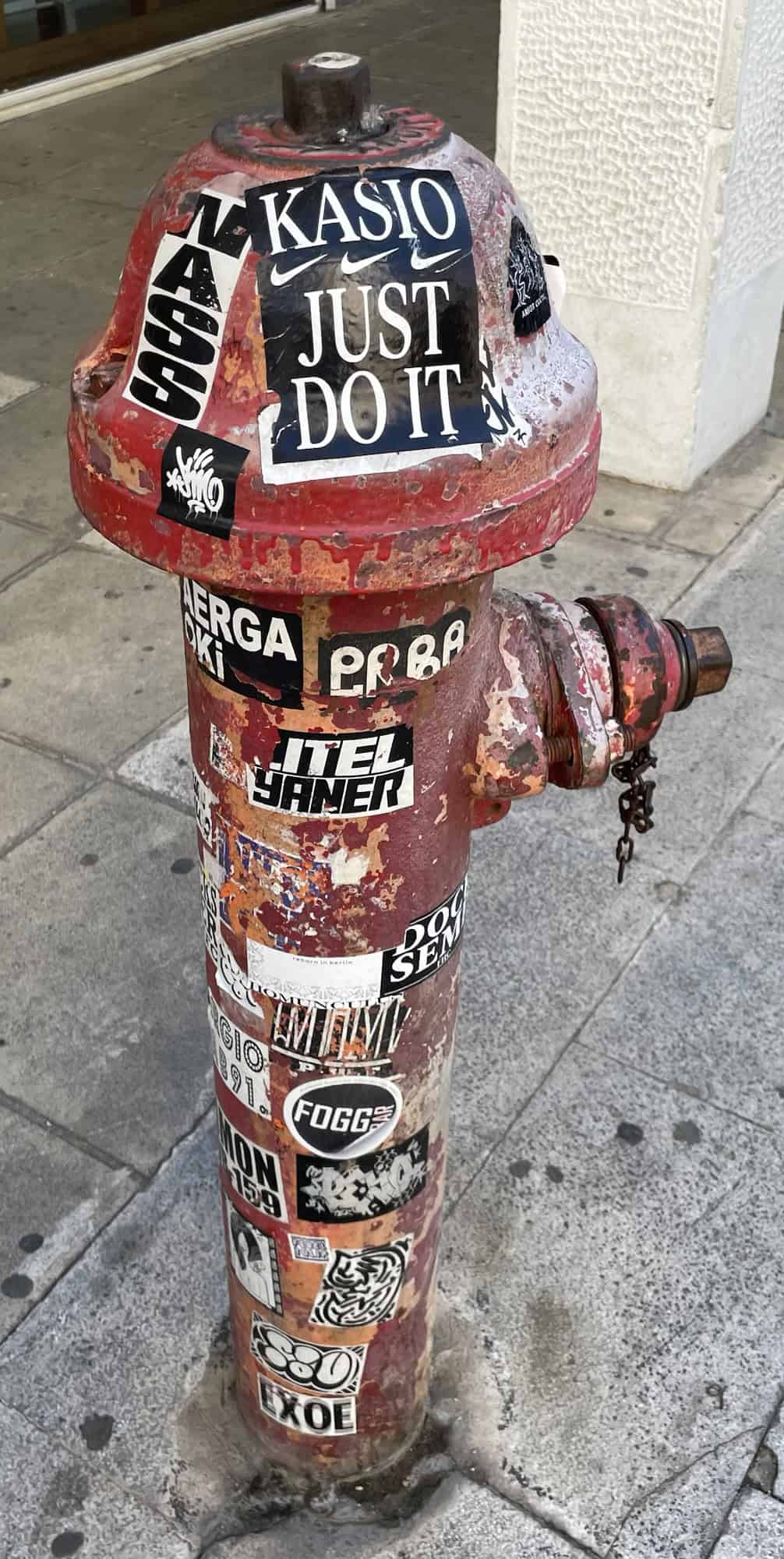 Ein roter Hydrant übersäht mit Aufklebern.