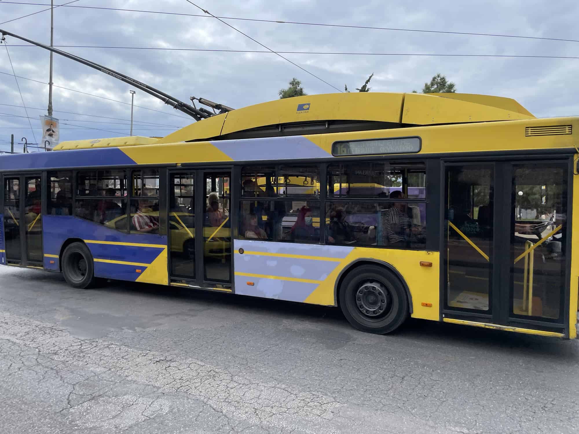 Gelb-blauer Linienbus mit Stromabnehmer oben.