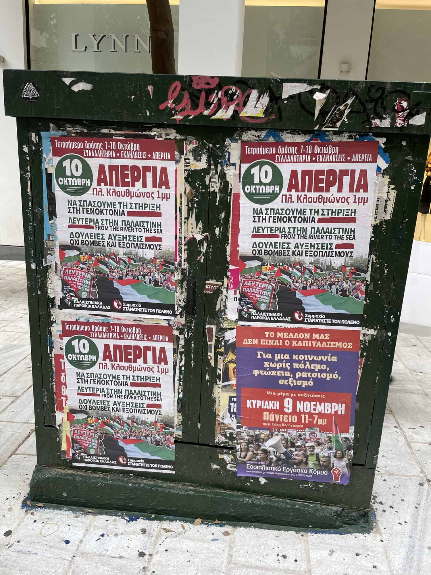 Dunkelgrüner Stromkasten übersäht mit Reklamen.