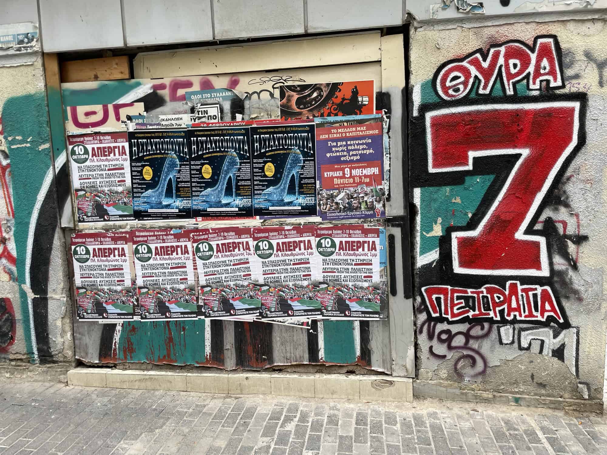 Eine Wand, lunks Reklameplakate, rechts Graffitis mit einer geoßen '7'.