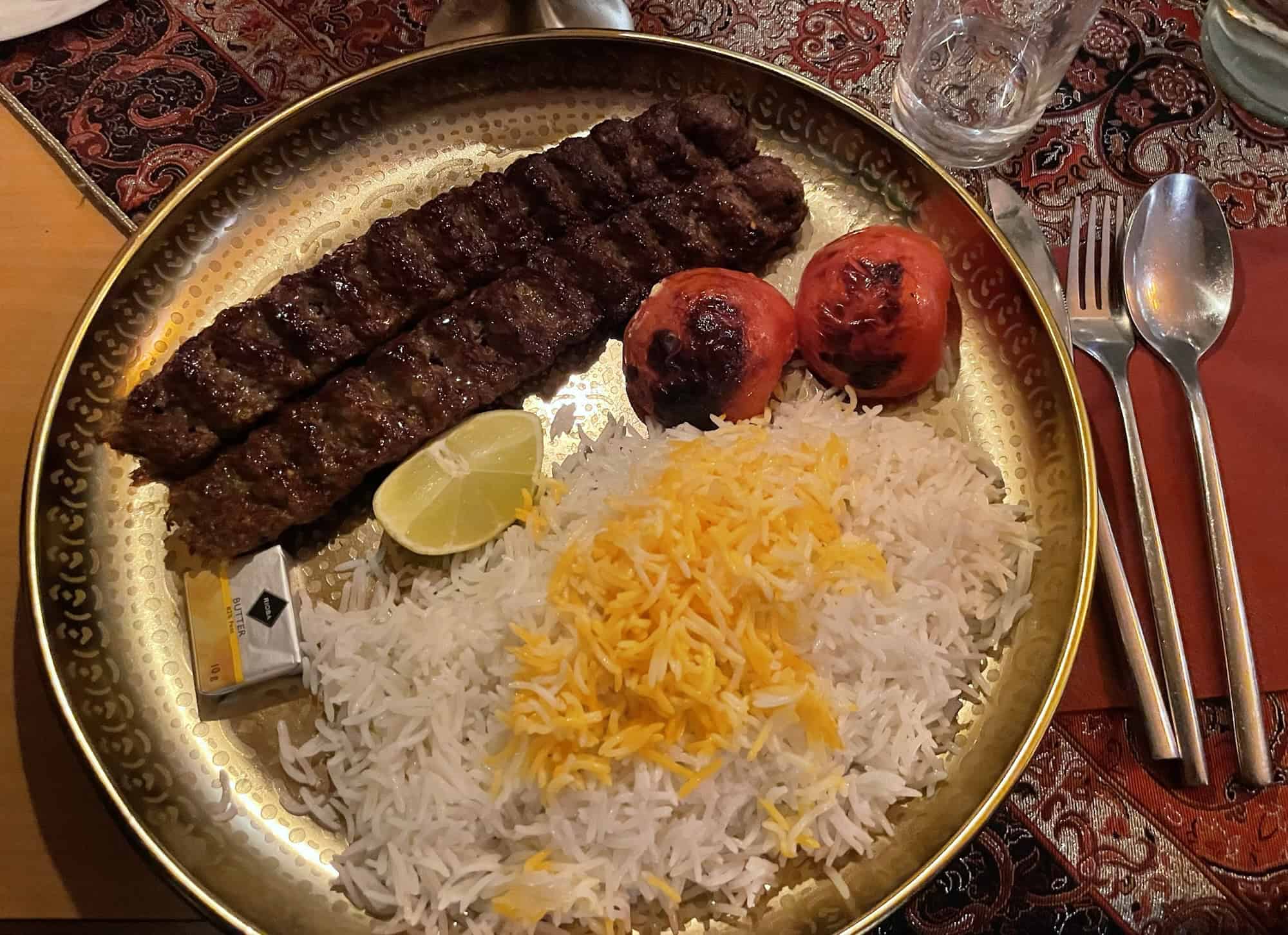 Zwei Hackspieße Lamm und Hähhnchen mit Reis und Grilltomaten.