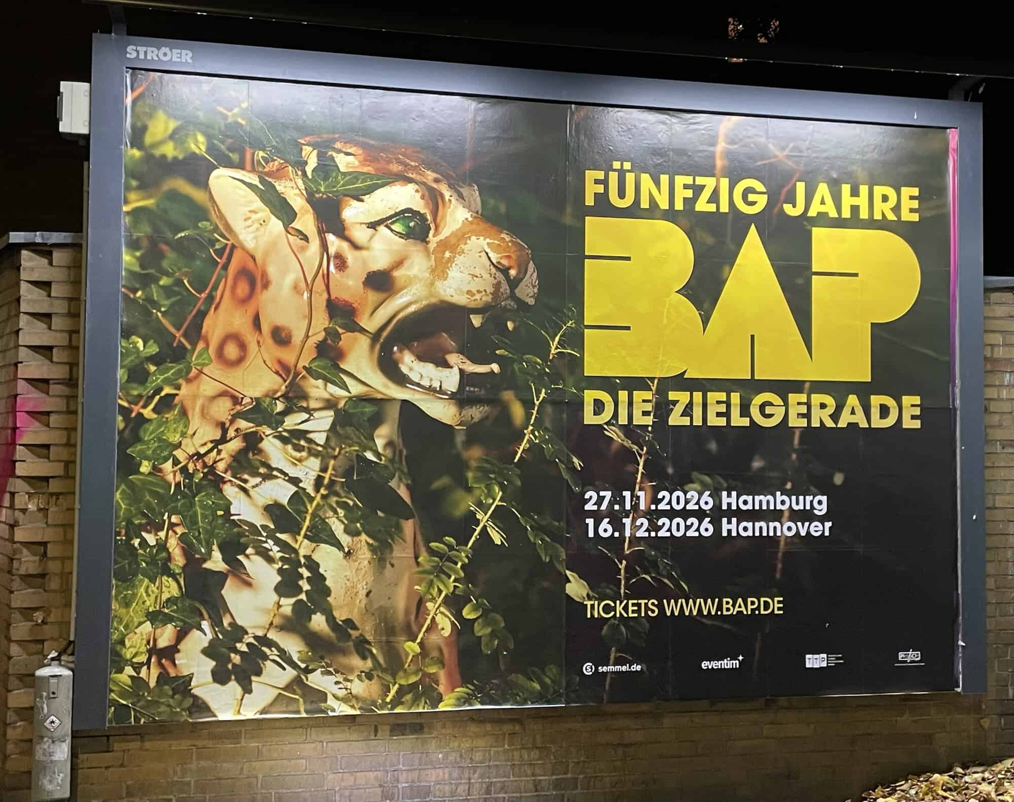 Außenwerbungsplakat: FÜNFZIG JAHRE BAP DIE ZIELGERADE mit abgebildeter Raubktze.