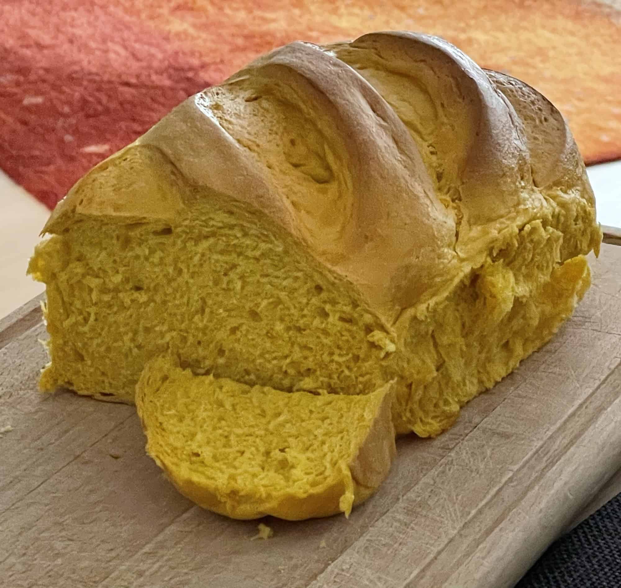 Angeschnittener gelber Kürbisstuten auf Holzbrett.