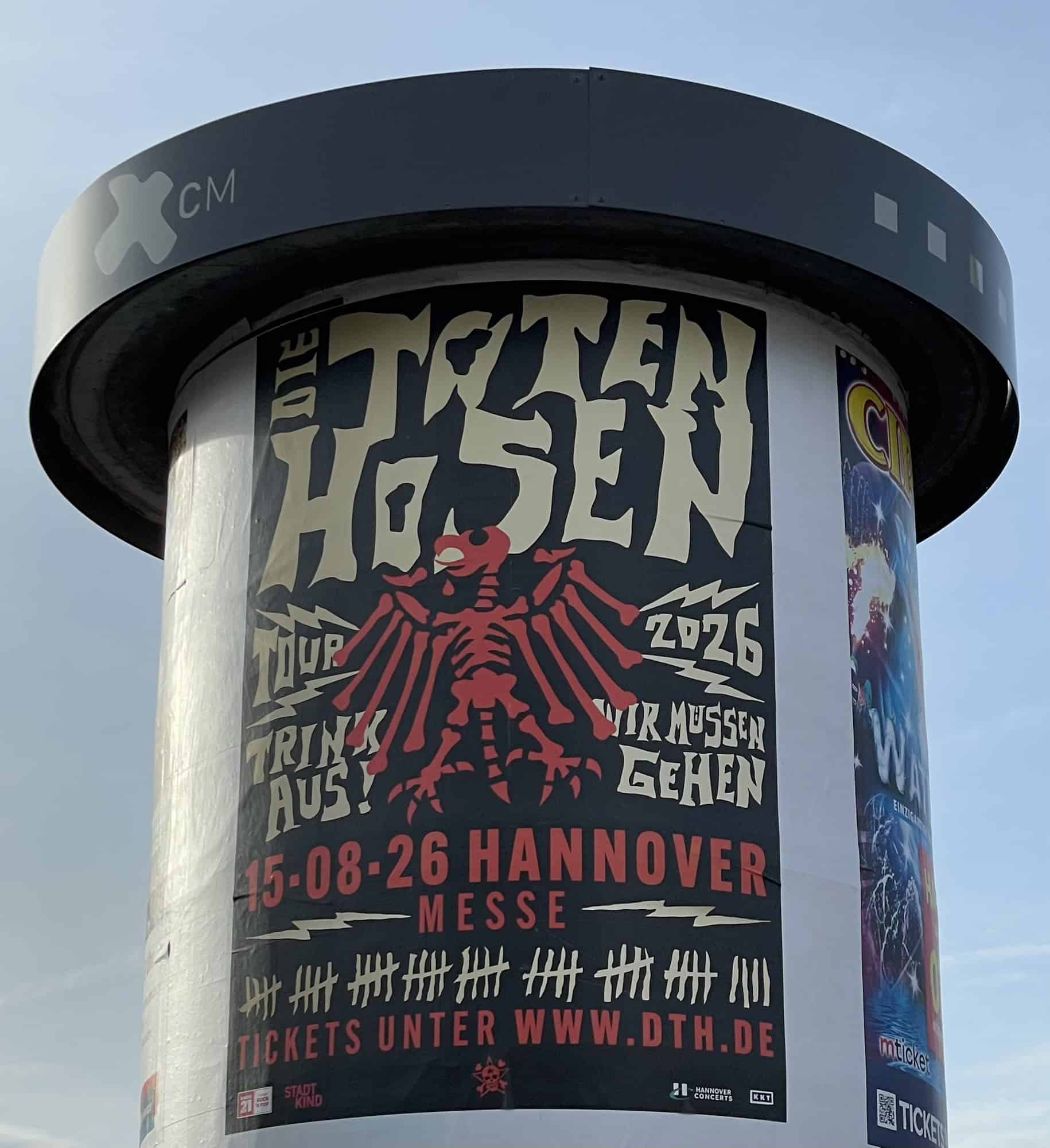 Litfaßsäule mit Metallkranz oben und Tote-Hosen-Konzertwerbung