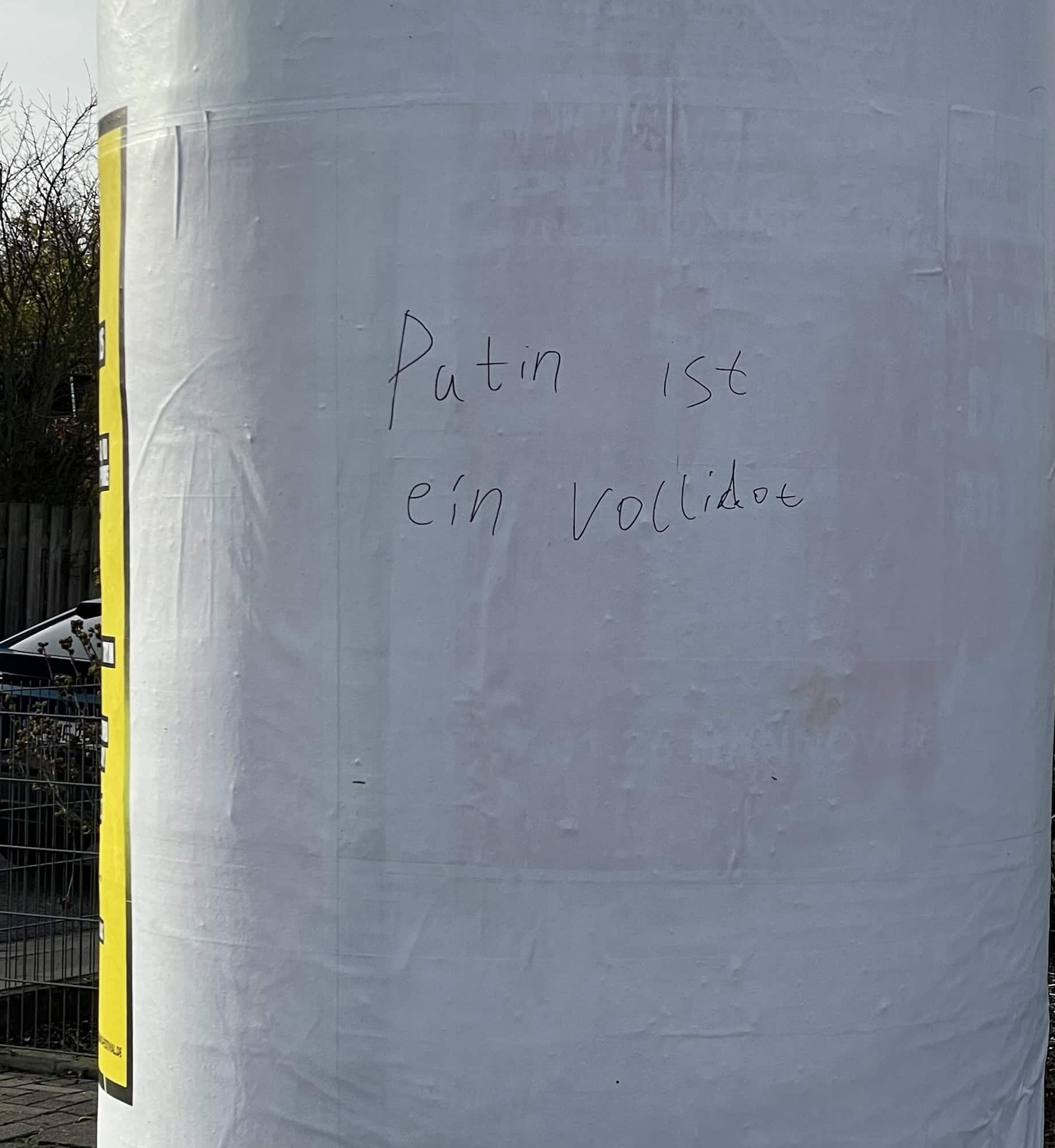 Litfaßsäule, weiß ohne Reklame mit Angeschriebenen.