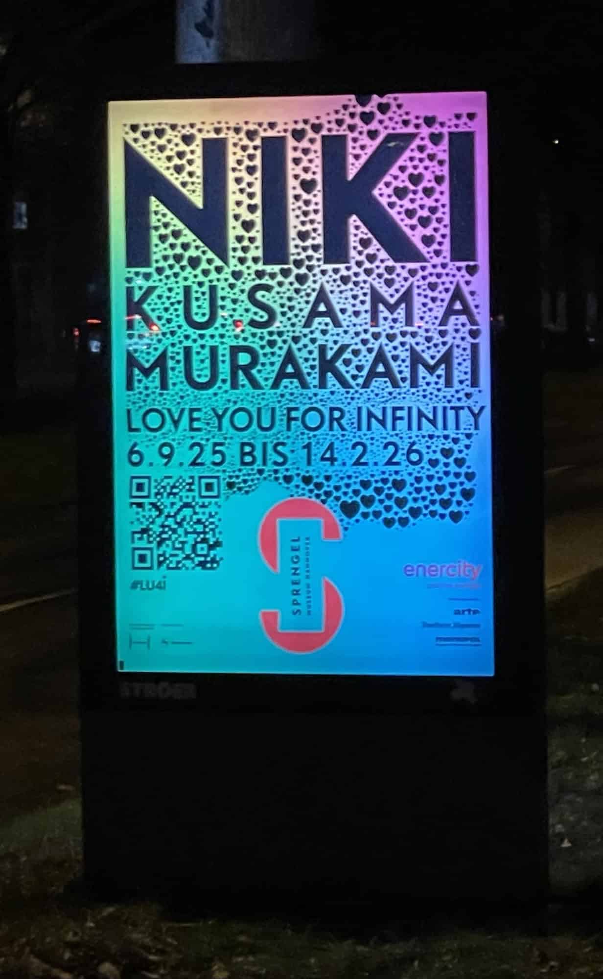 Abends beleuchtete Außenreklame für die Ausstellung NIKI USAMA MURAKAMI im Sprengelmuseum.