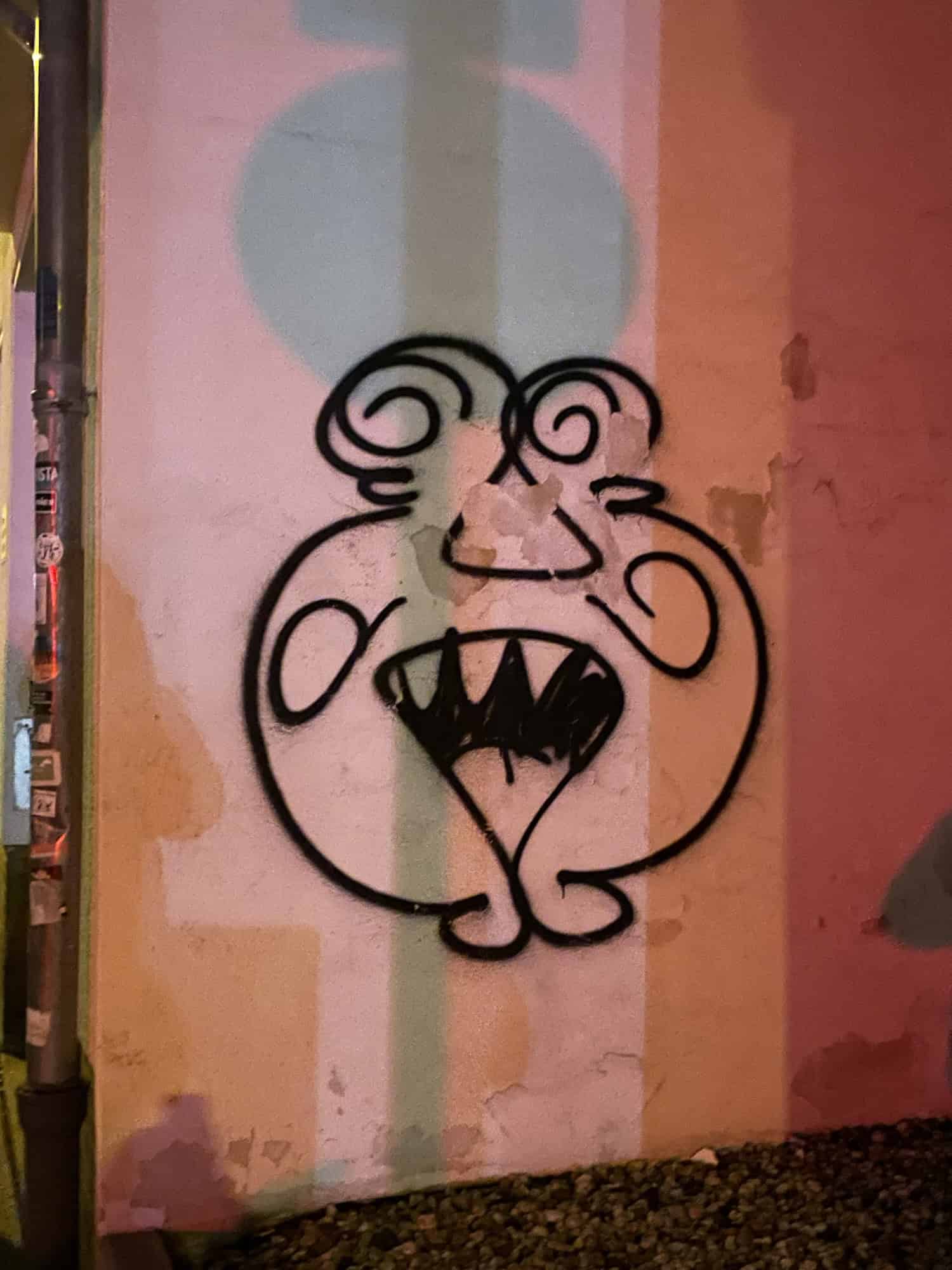 Iconidches Comicgesichtauf rosa-orange-roter Wand.