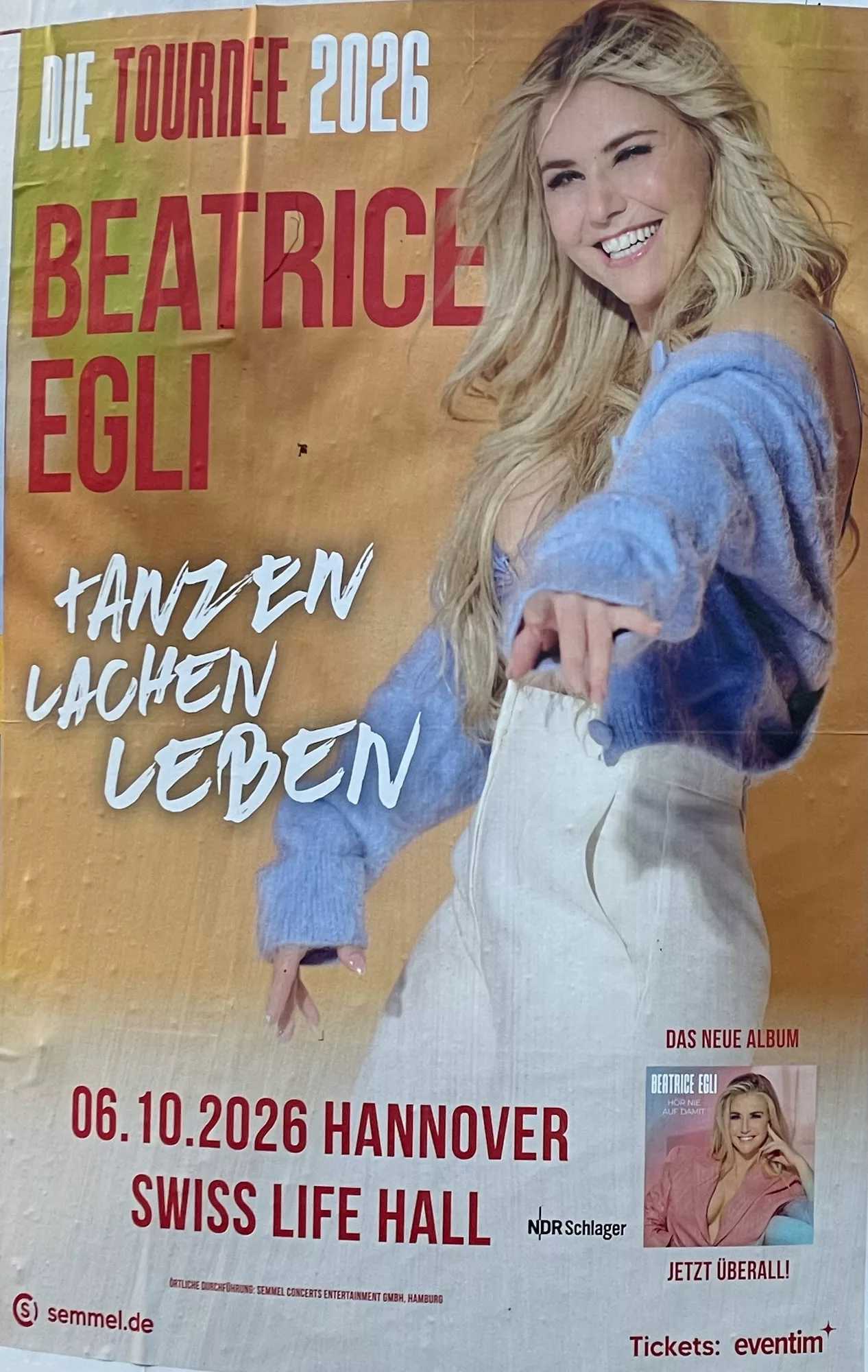 Beatrice Egli Konzertplakat für Oktober 2026, sie in Farbe lächel, seitlich stehend und streckt den linken Arm 'aus dem Plakat'.