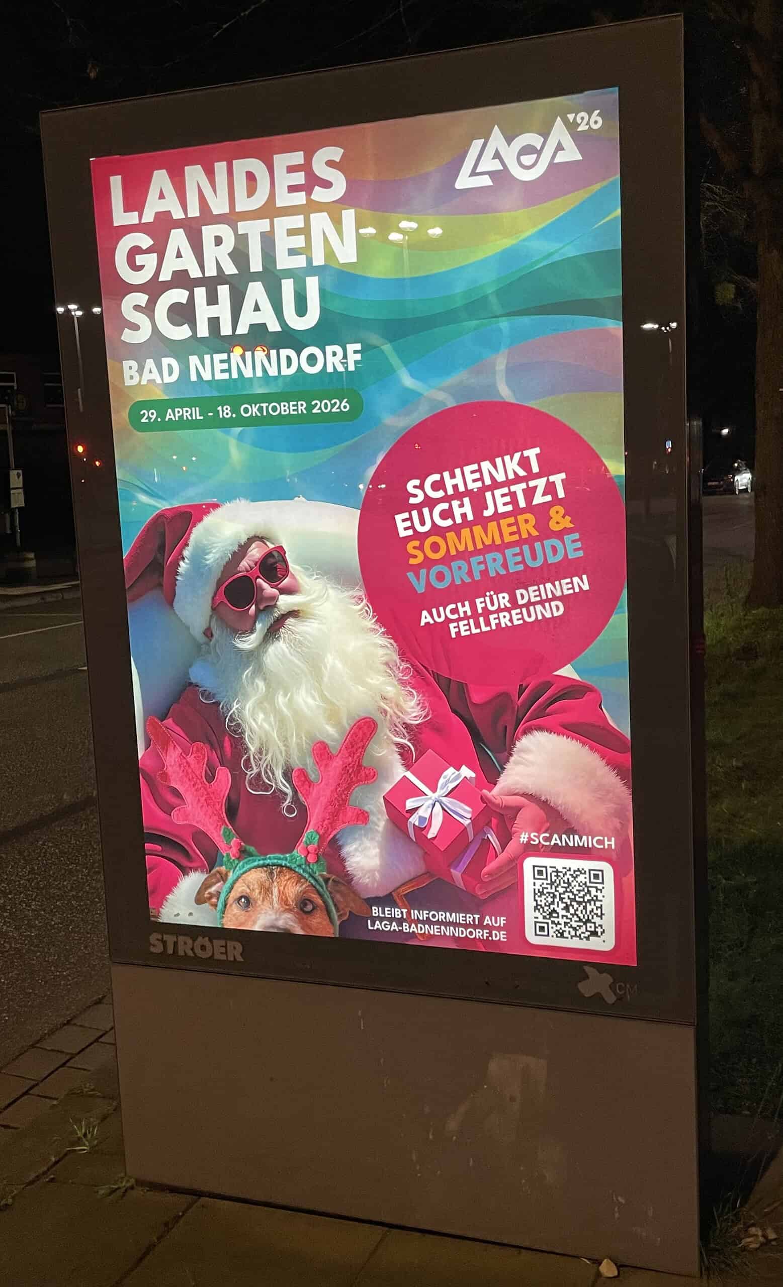 Abends Außenreklame für die Landesgartenschau in. Bad Nenndorf im nächsten Jahr mit Weihnachtsmannmotiv.