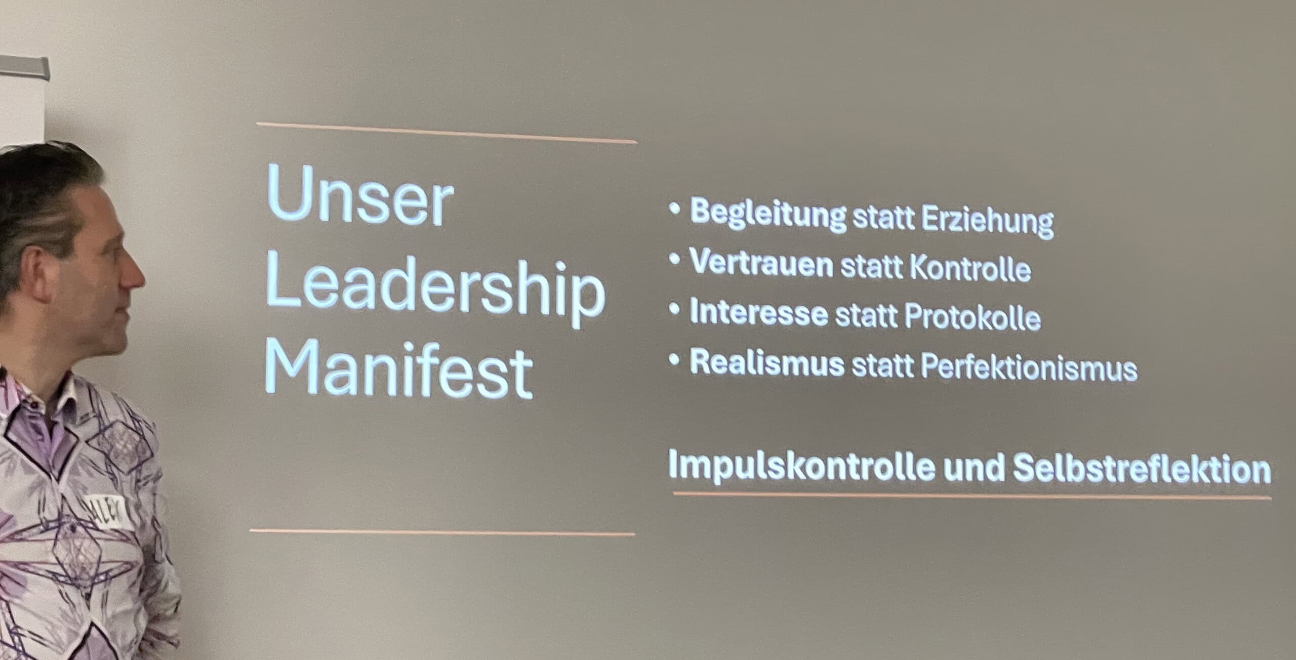Vortragende Alex und daneben das Leadership Manifest der beiden.