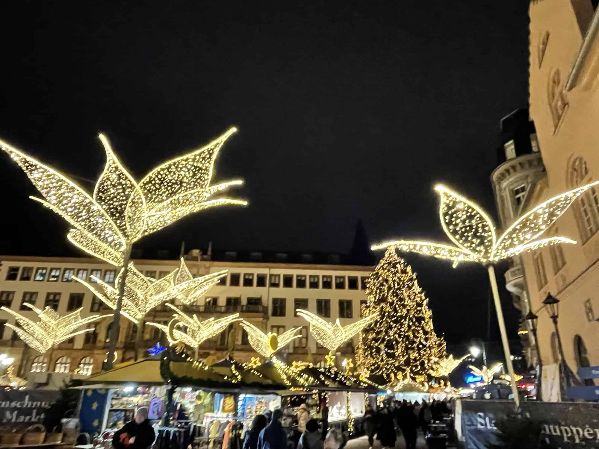 Weihnachtsmarktleuchtschmuck, Buden und Häuser im Hintergrund.